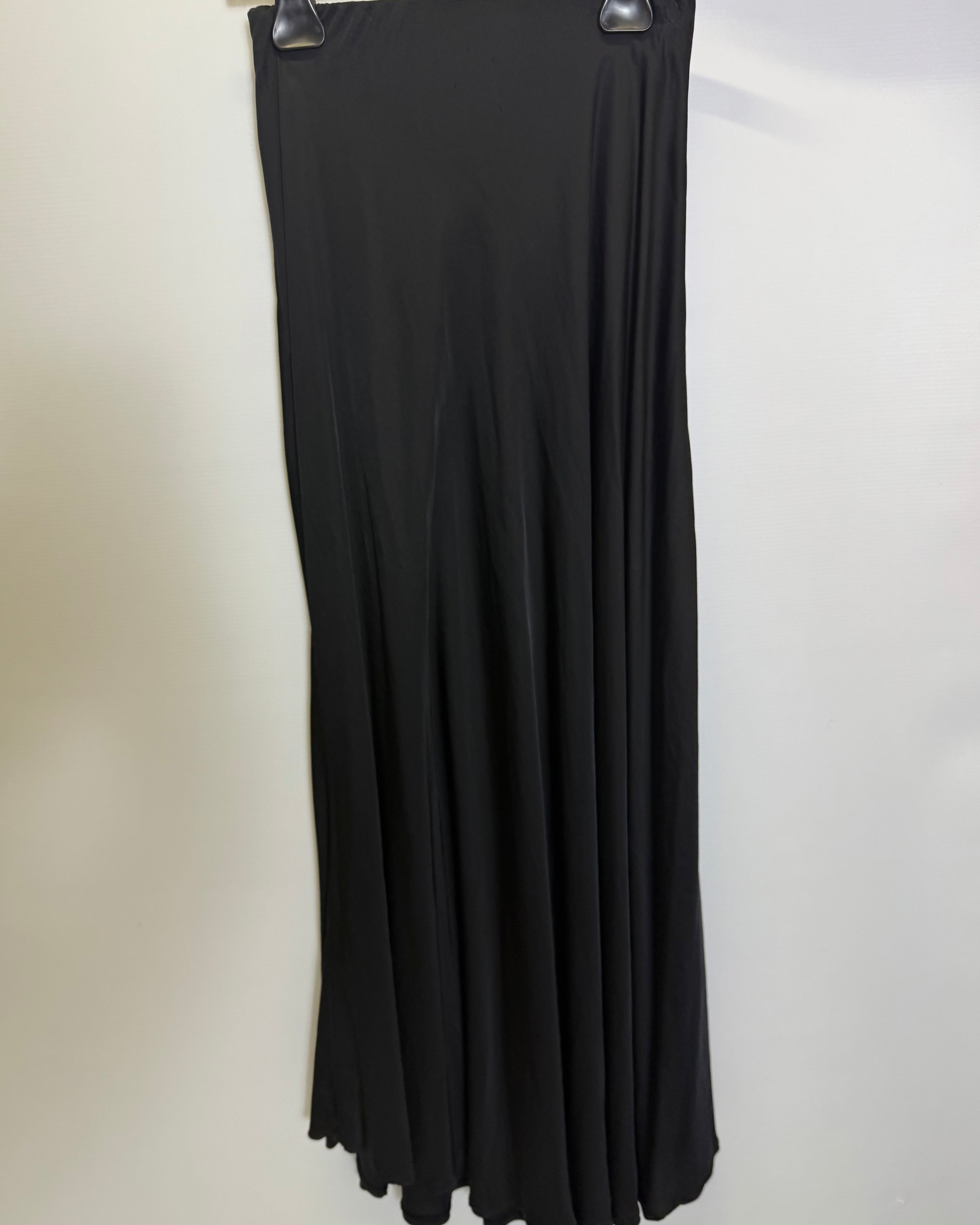Black dress on a hanger against a white background