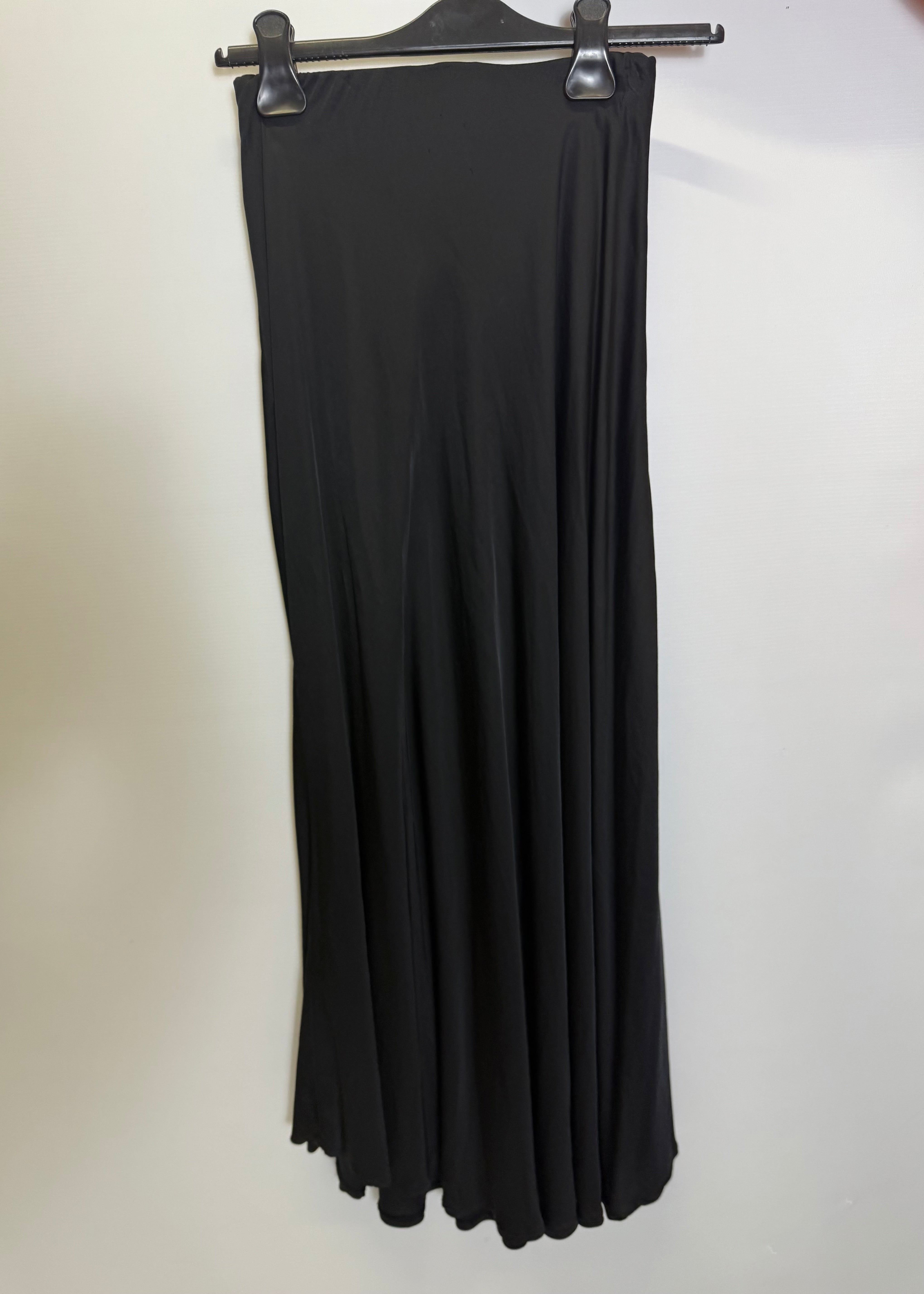 Black dress on a hanger against a white background