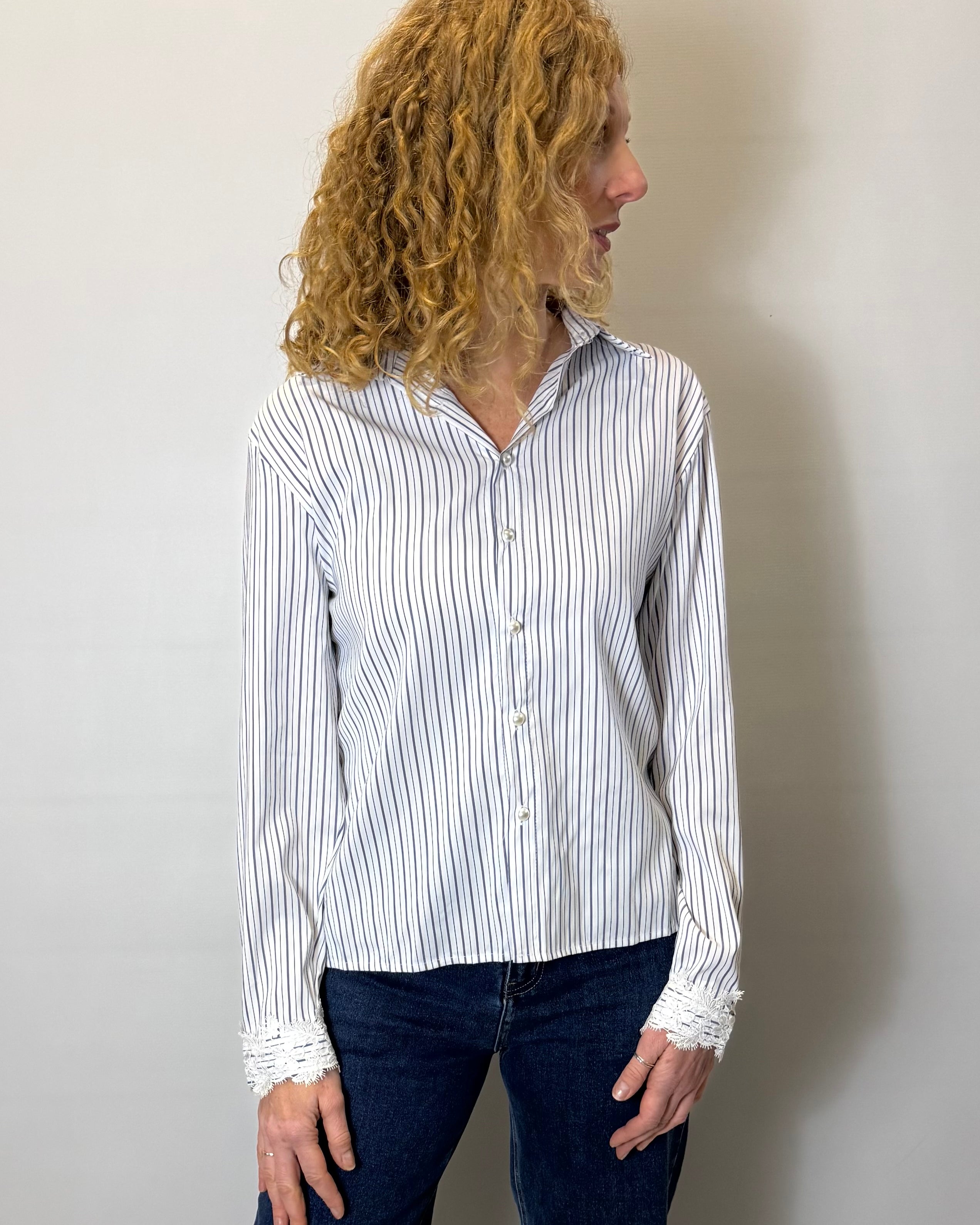 Person wearing a white and black striped shirt against a plain background
