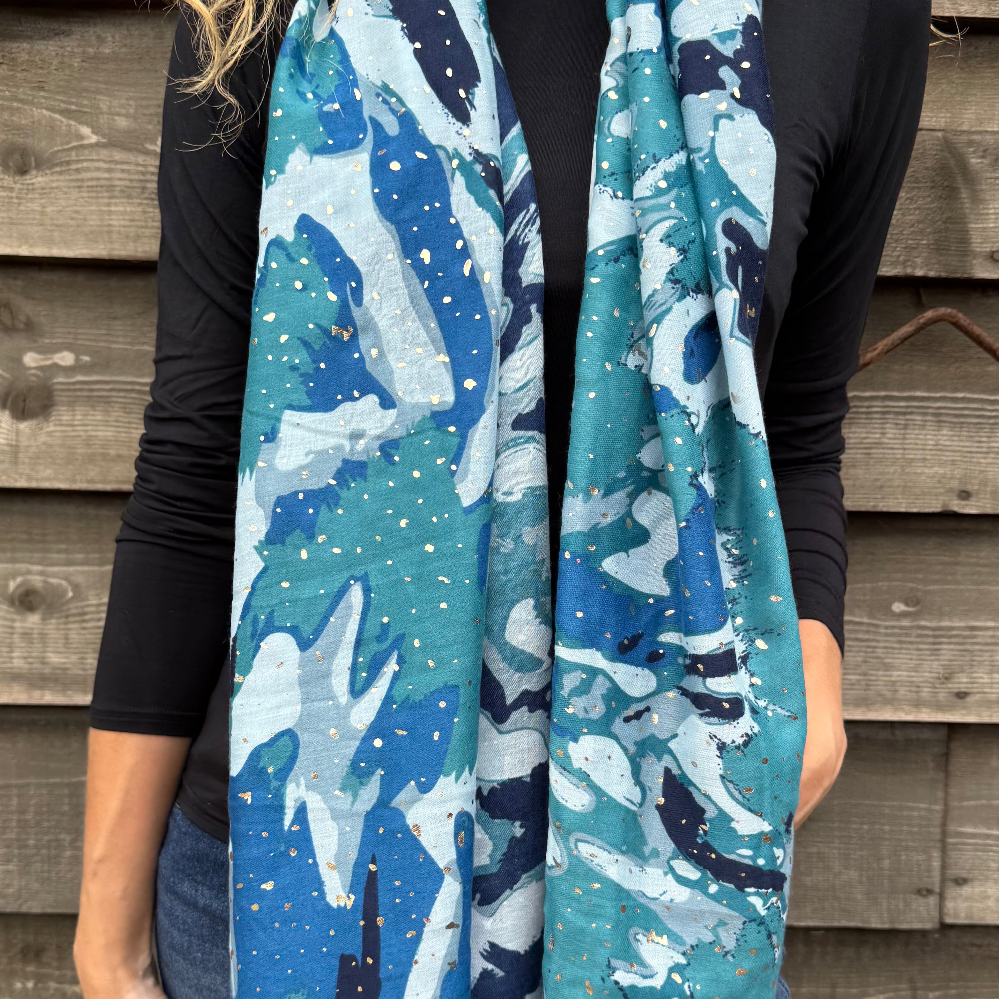 Person wearing a blue and white patterned scarf against a wooden wall.