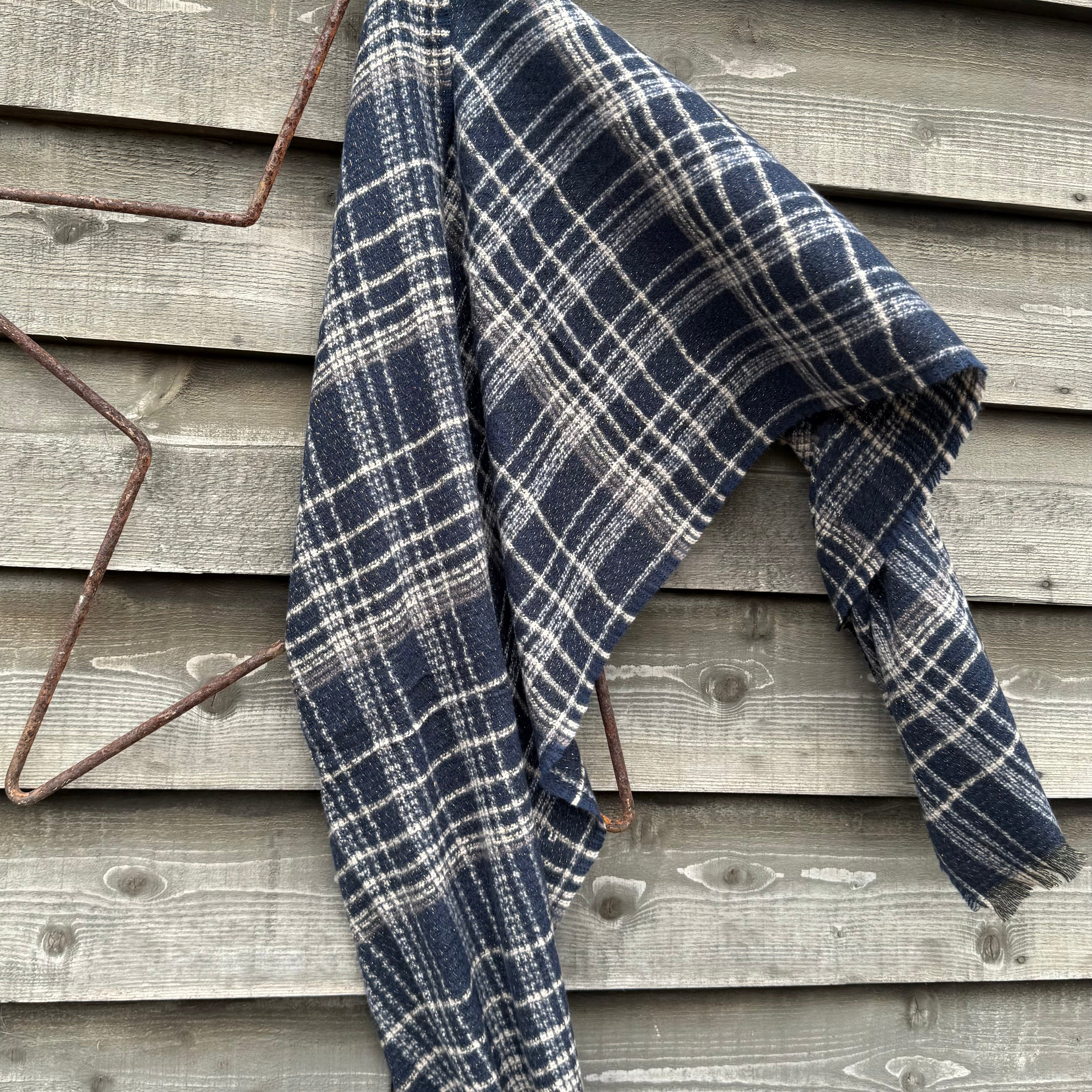 Blue and white plaid blanket draped over a wooden surface
