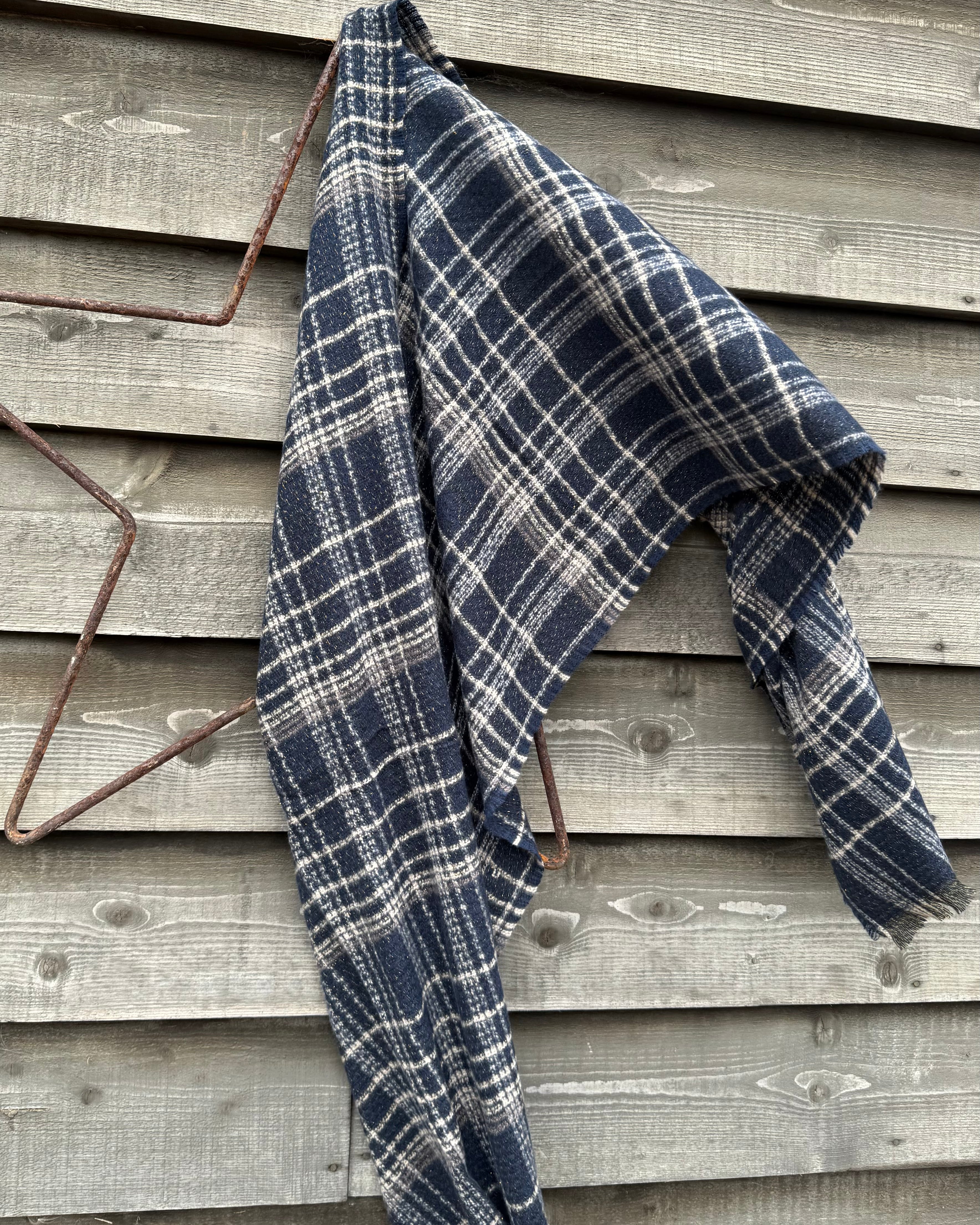 Blue and white plaid blanket draped over a wooden surface