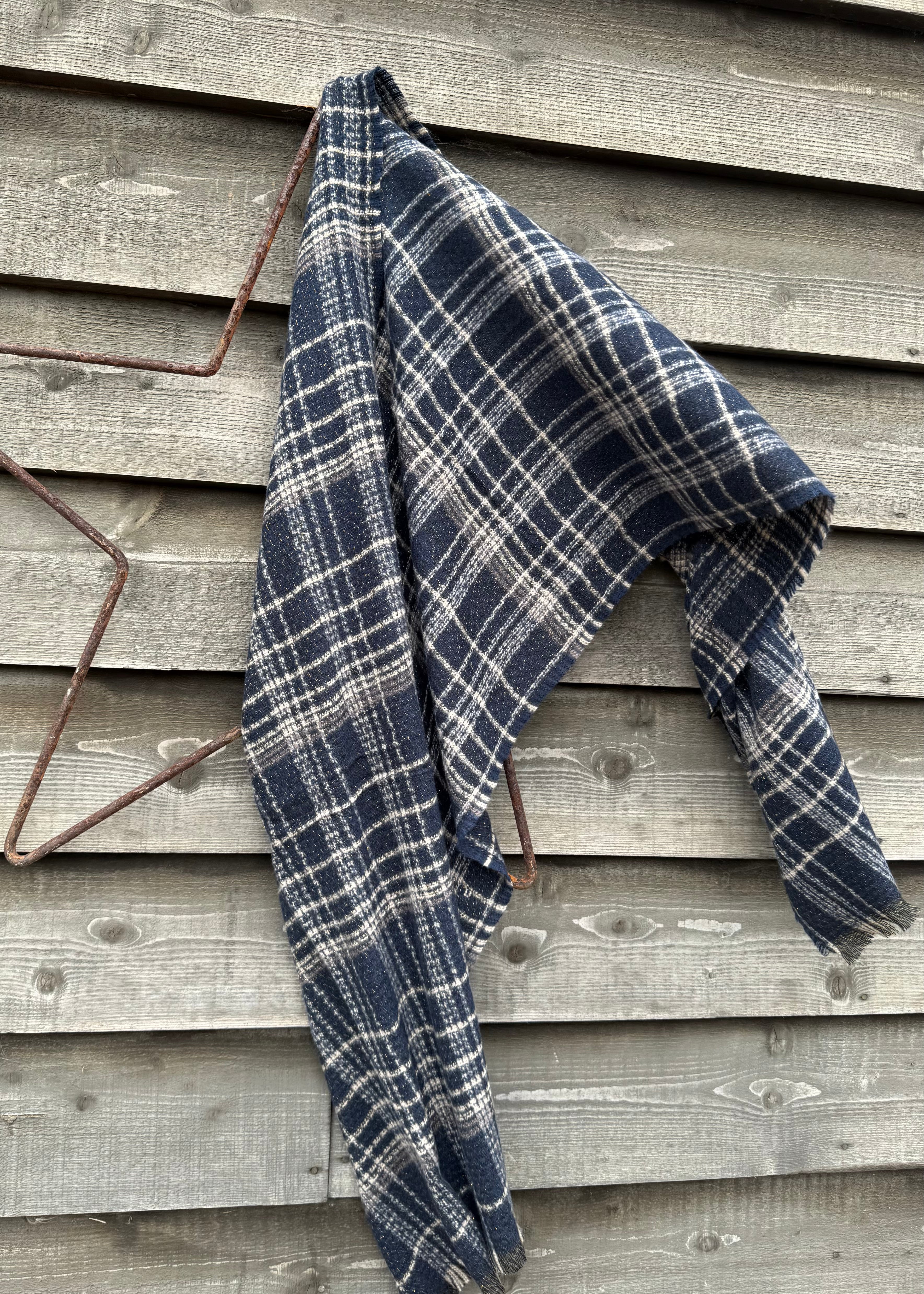 Blue and white plaid blanket draped over a wooden surface
