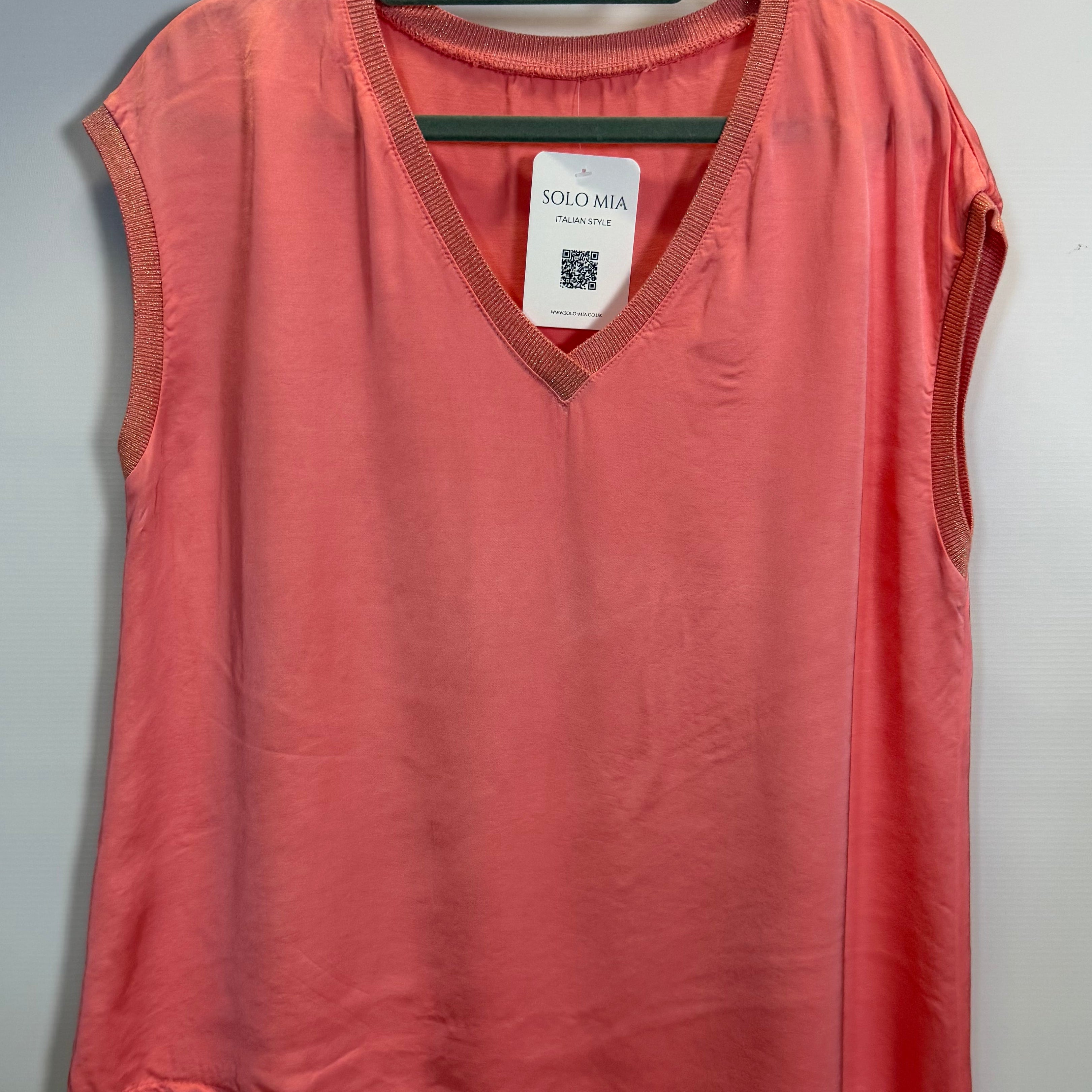 Red shirt on a hanger with a tag against a gray background