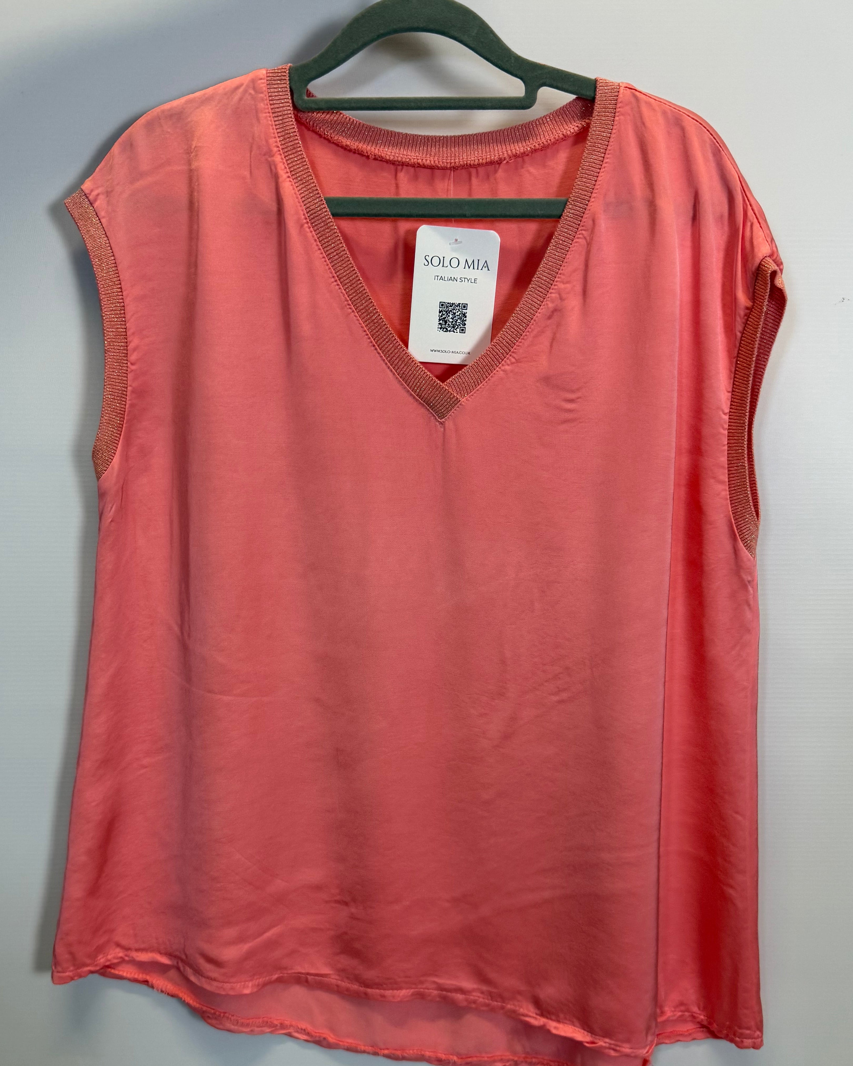 Red shirt on a hanger with a tag against a gray background