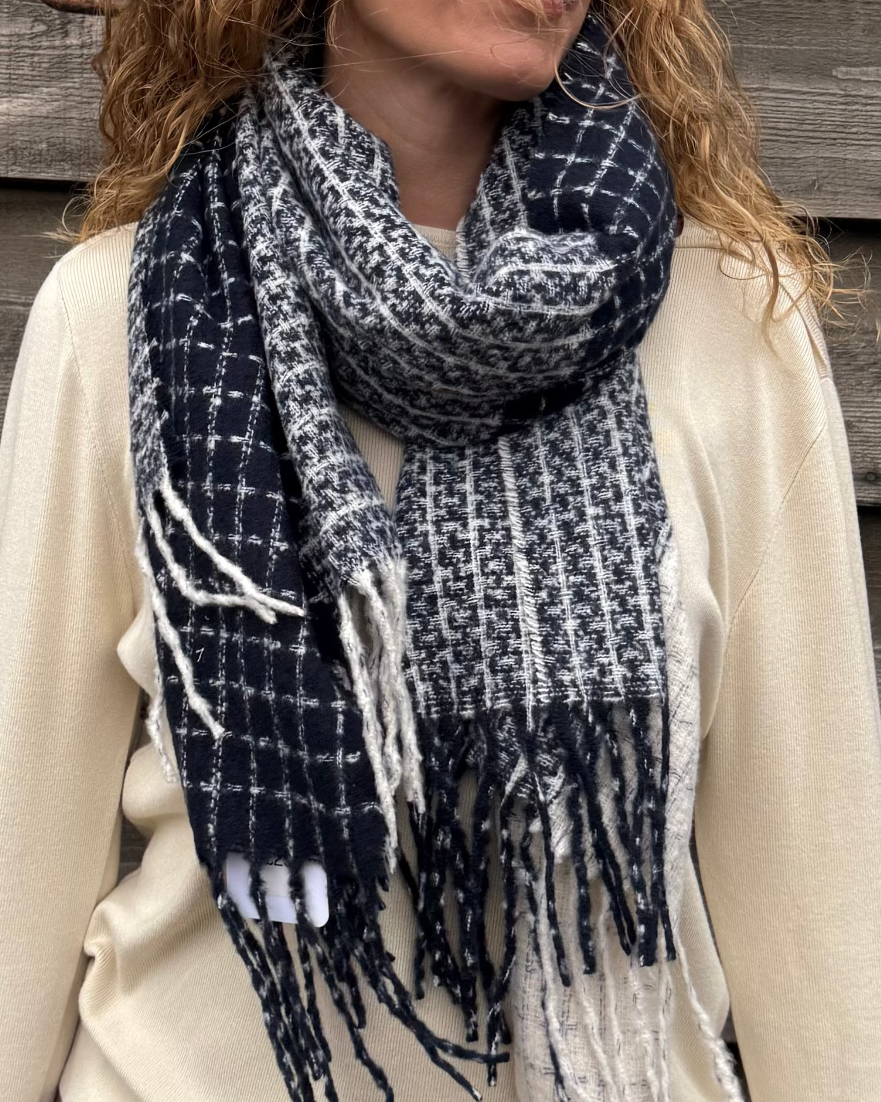 Woman wearing a blue and white plaid scarf against a wooden background