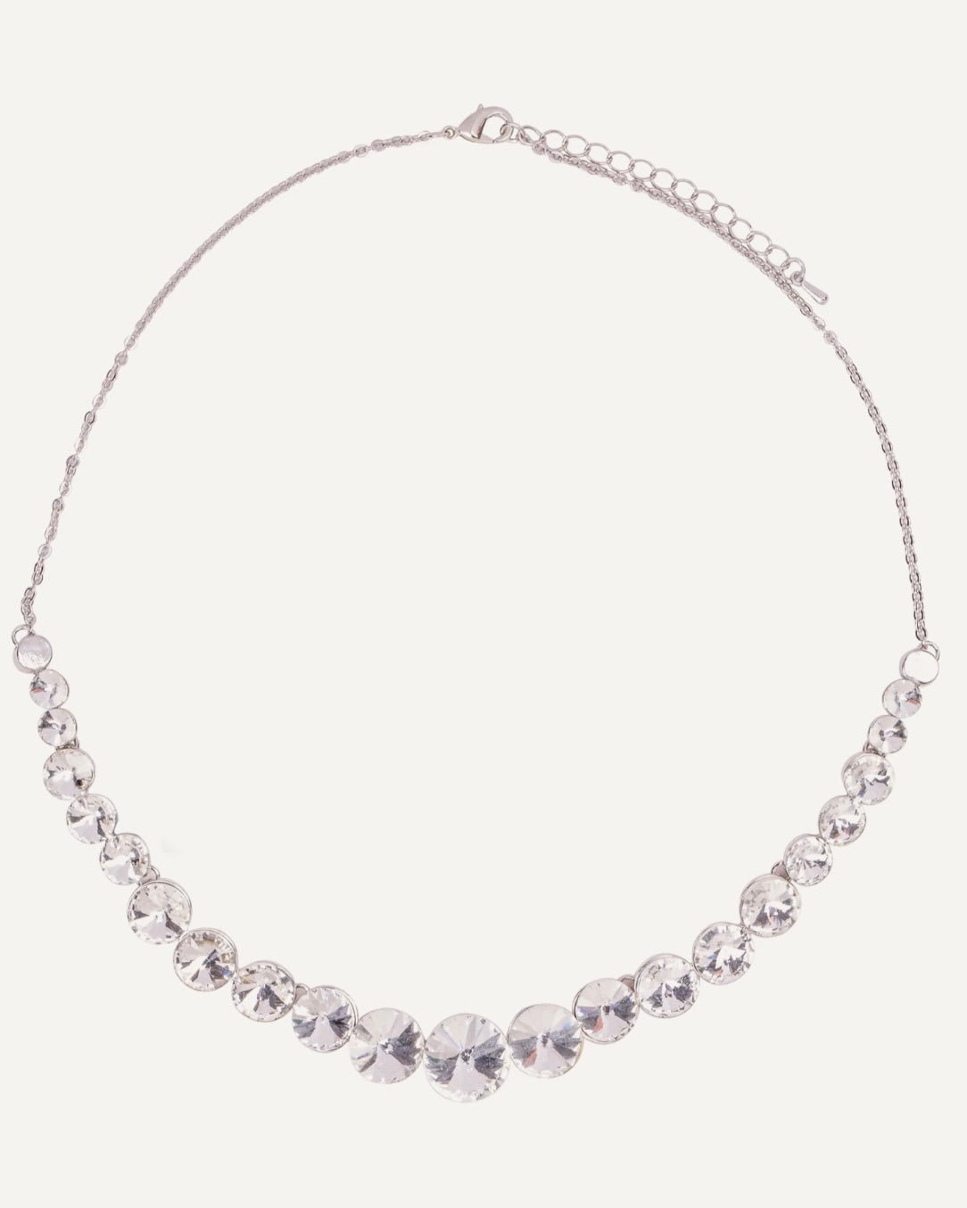 Silver necklace with clear crystals on a white background