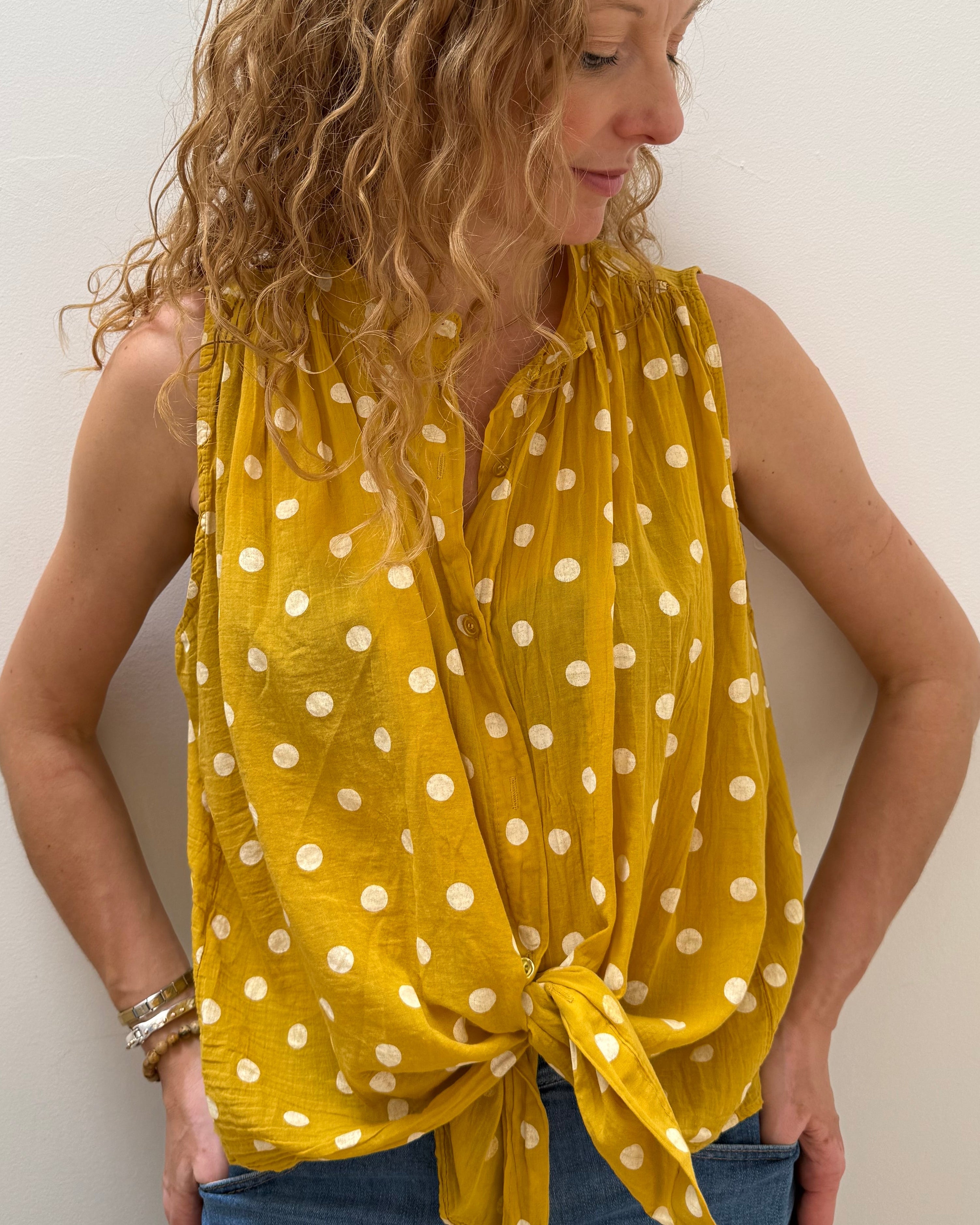 Woman wearing a yellow polka dot dress on a white background