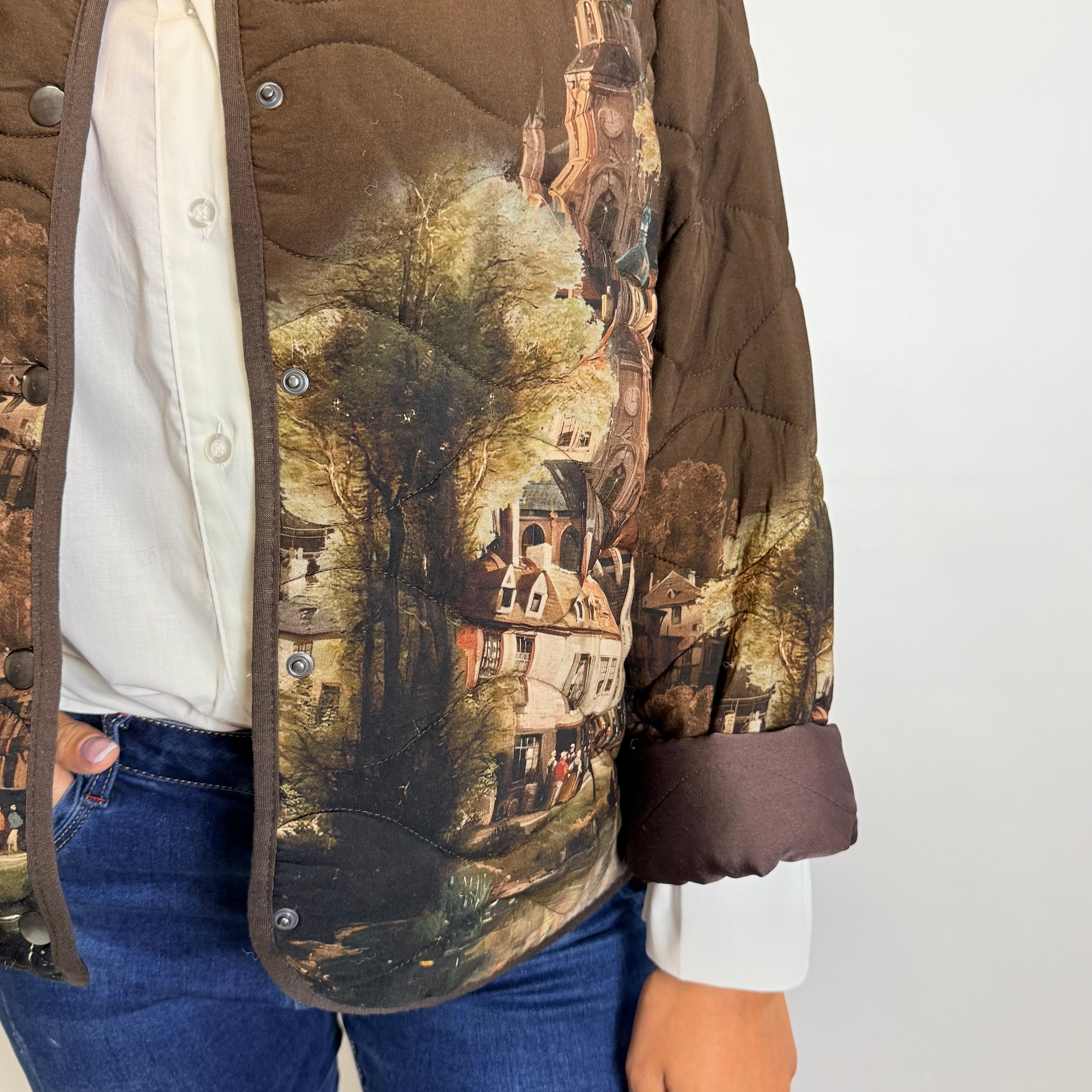 Person wearing a jacket with a scenic print on a plain background