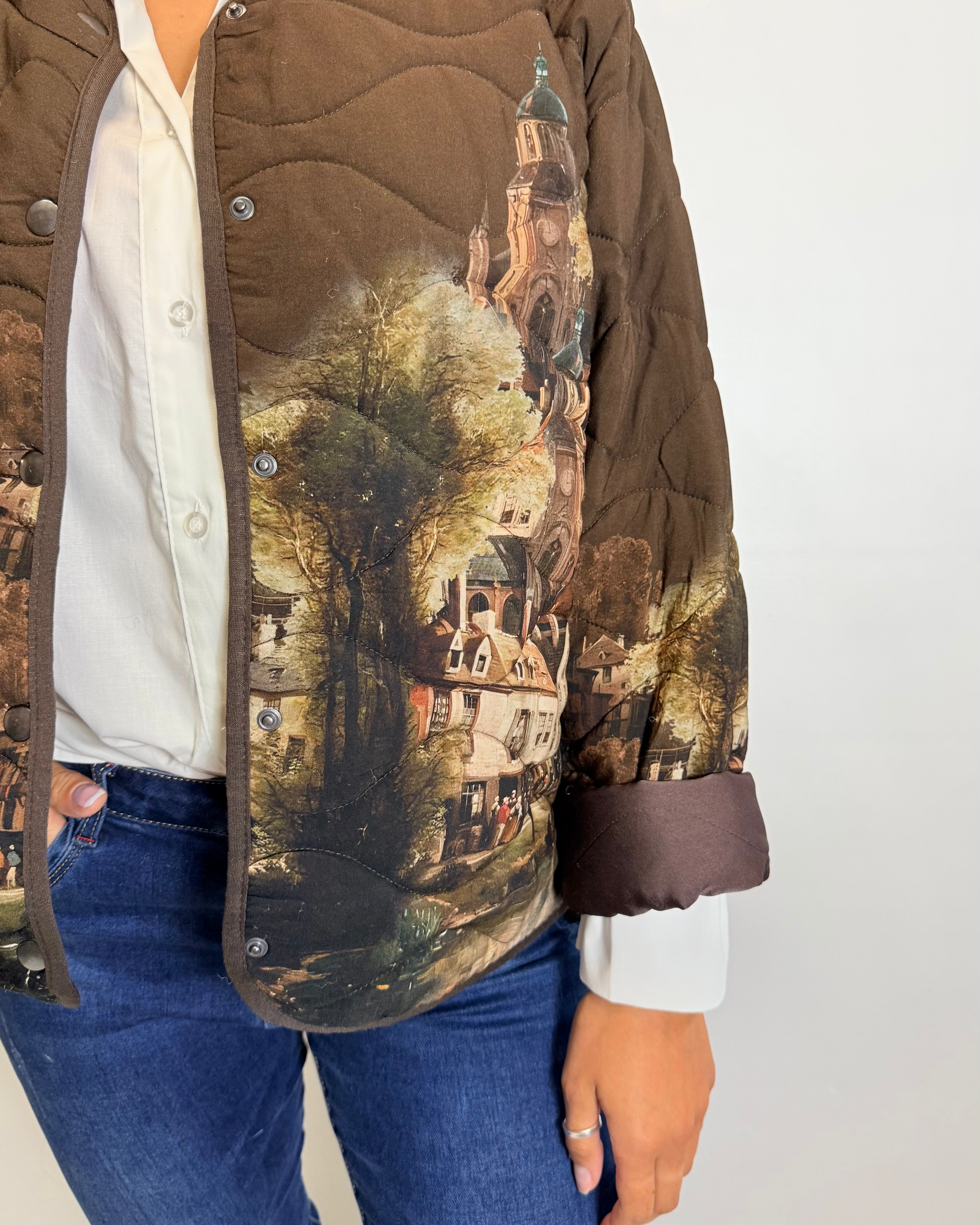 Person wearing a jacket with a scenic print on a plain background