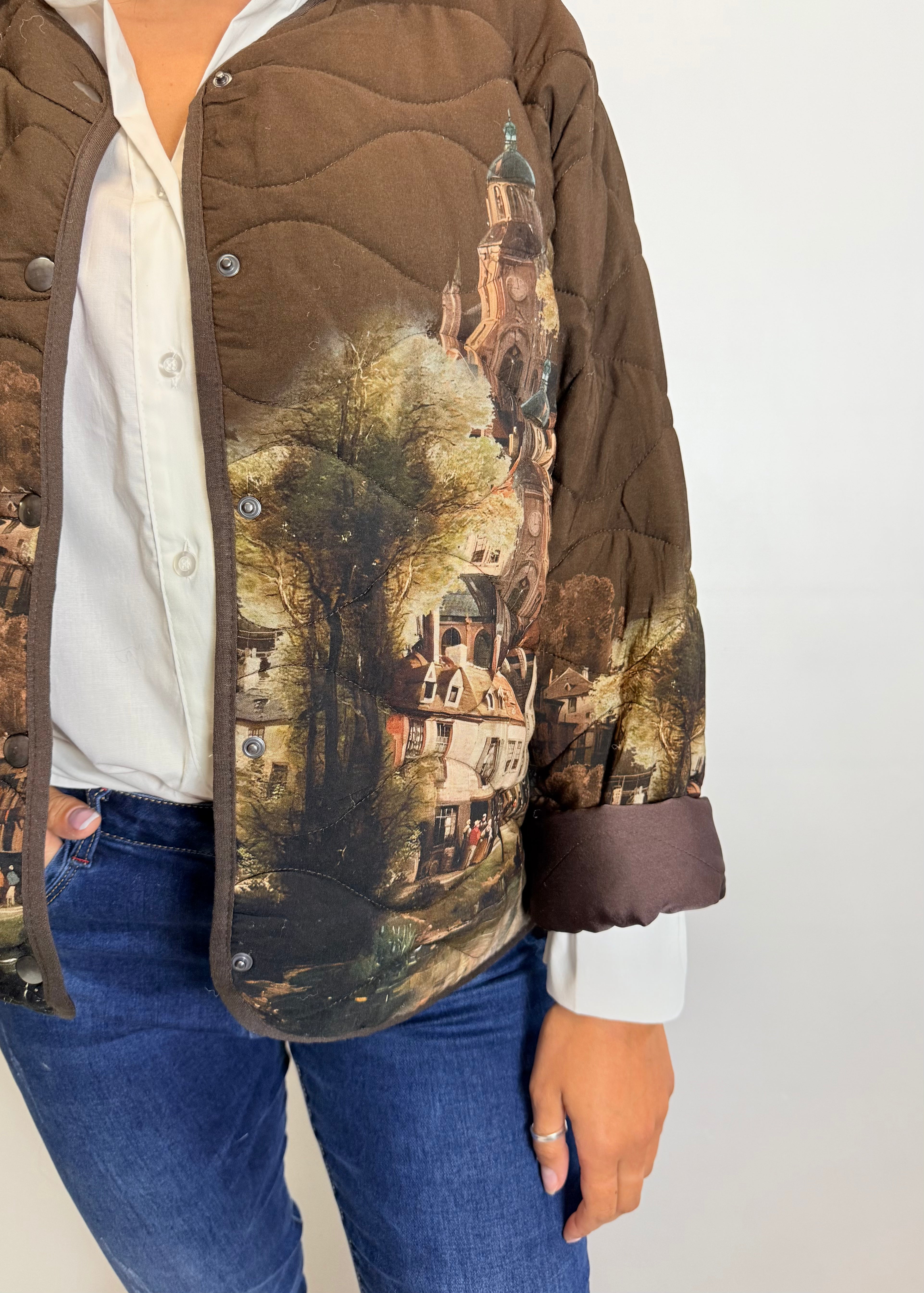 Person wearing a jacket with a scenic print on a plain background