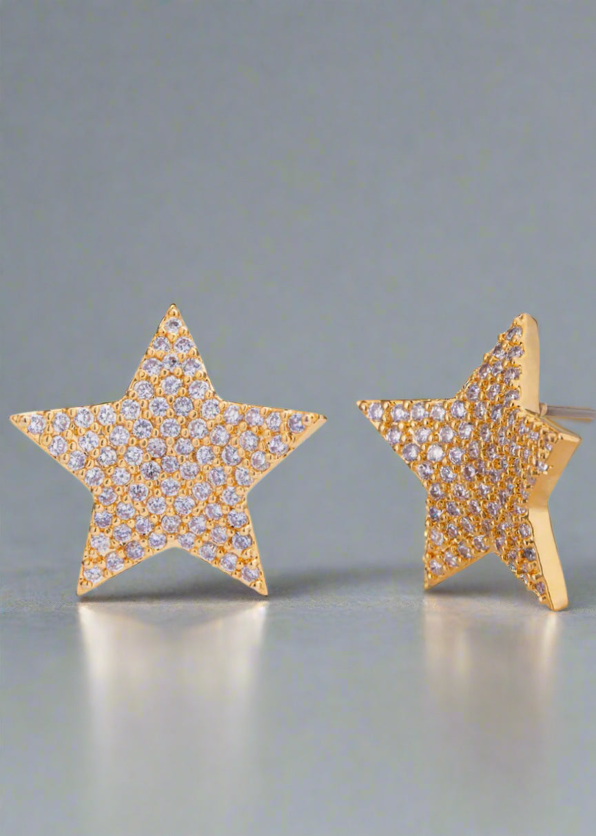 Star-shaped earrings with gold frame and clear stones on a white background
