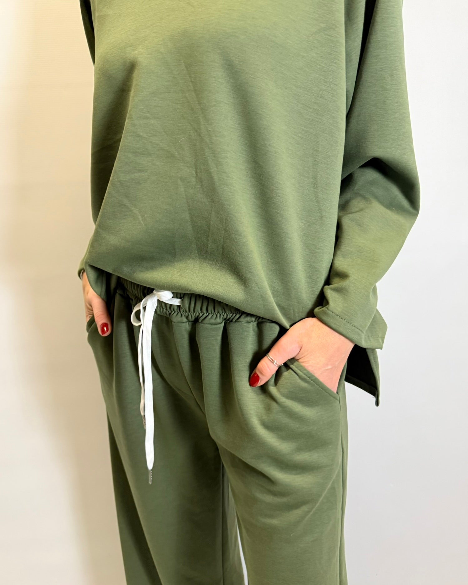 Green sweatshirt and pants set on a plain background