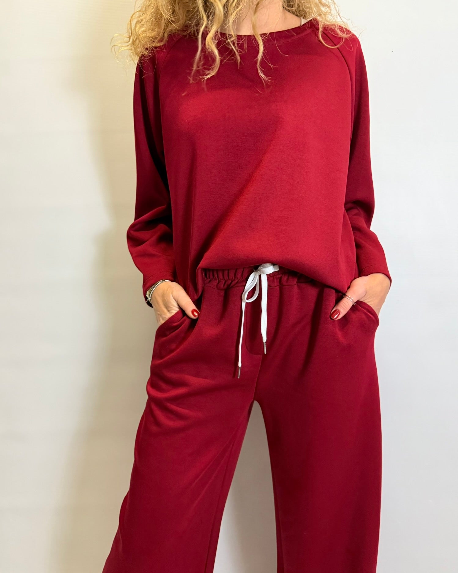 Person wearing a red lounge set against a plain background