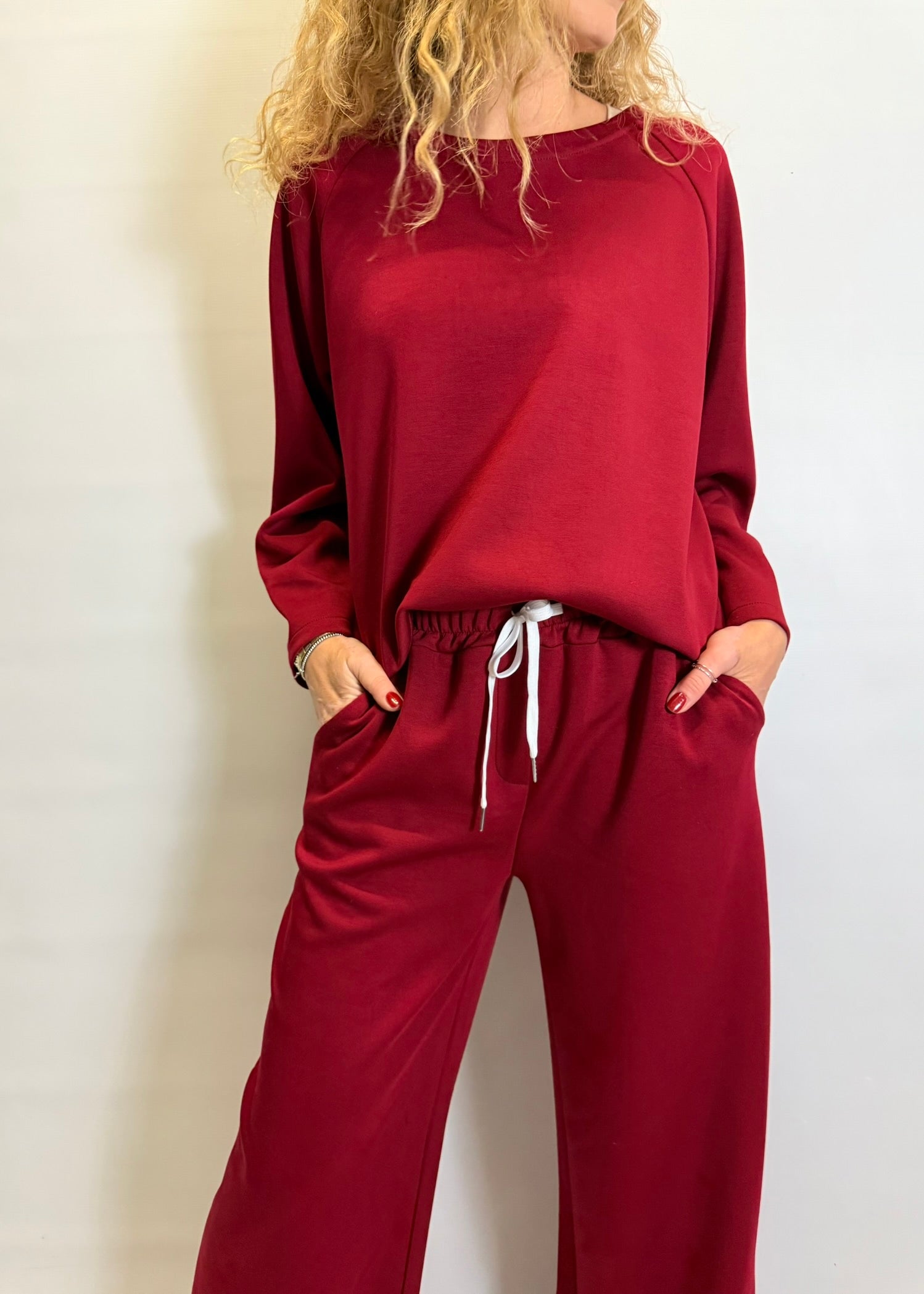 Person wearing a red lounge set against a plain background