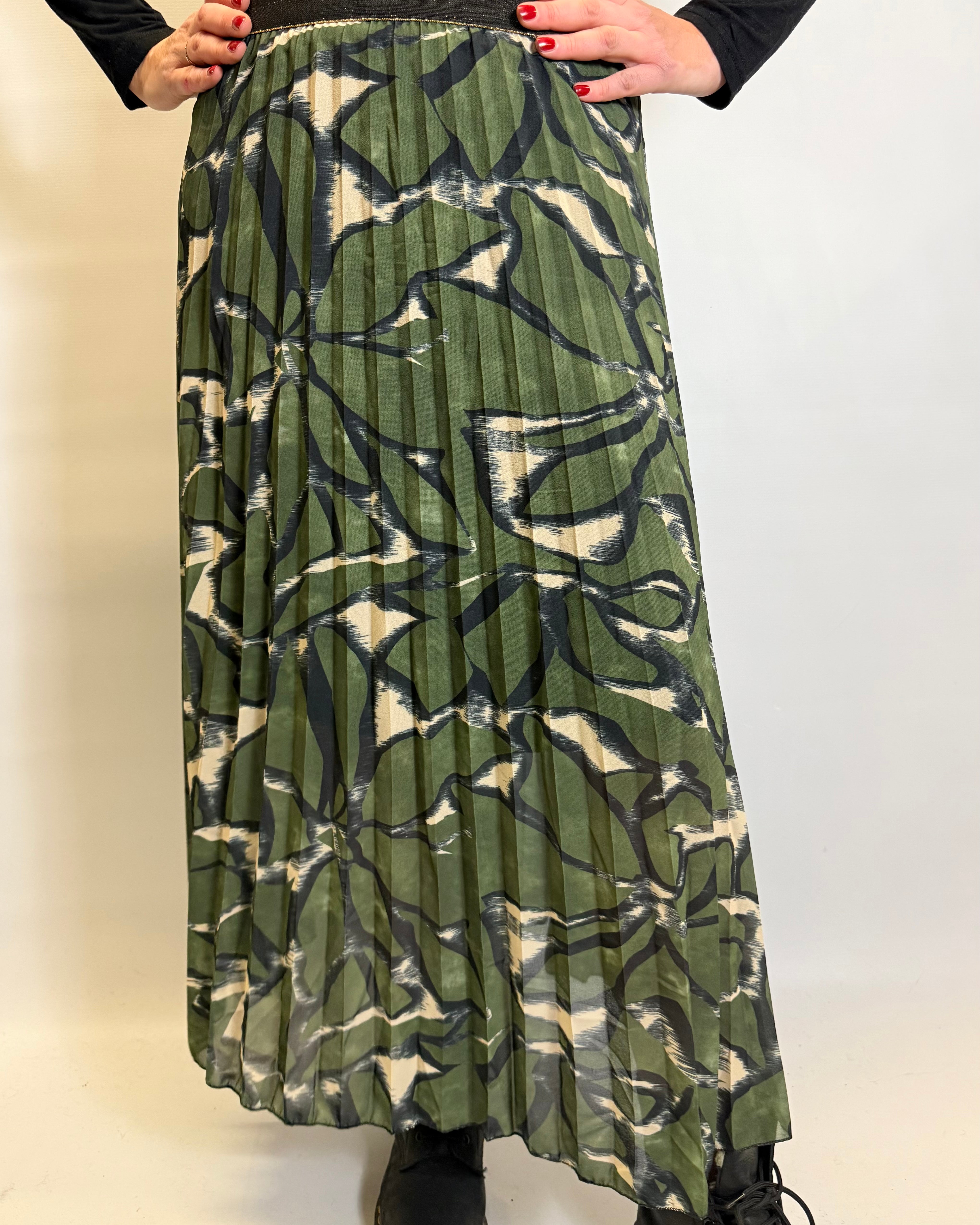 Person wearing a green patterned skirt on a white background