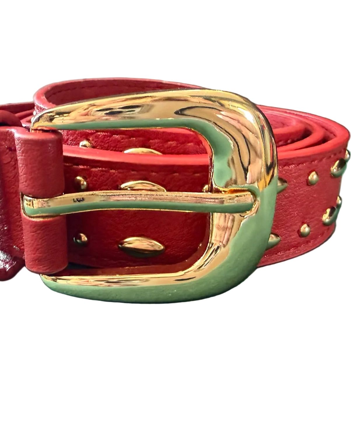 Red leather belt with gold buckle on a green surface