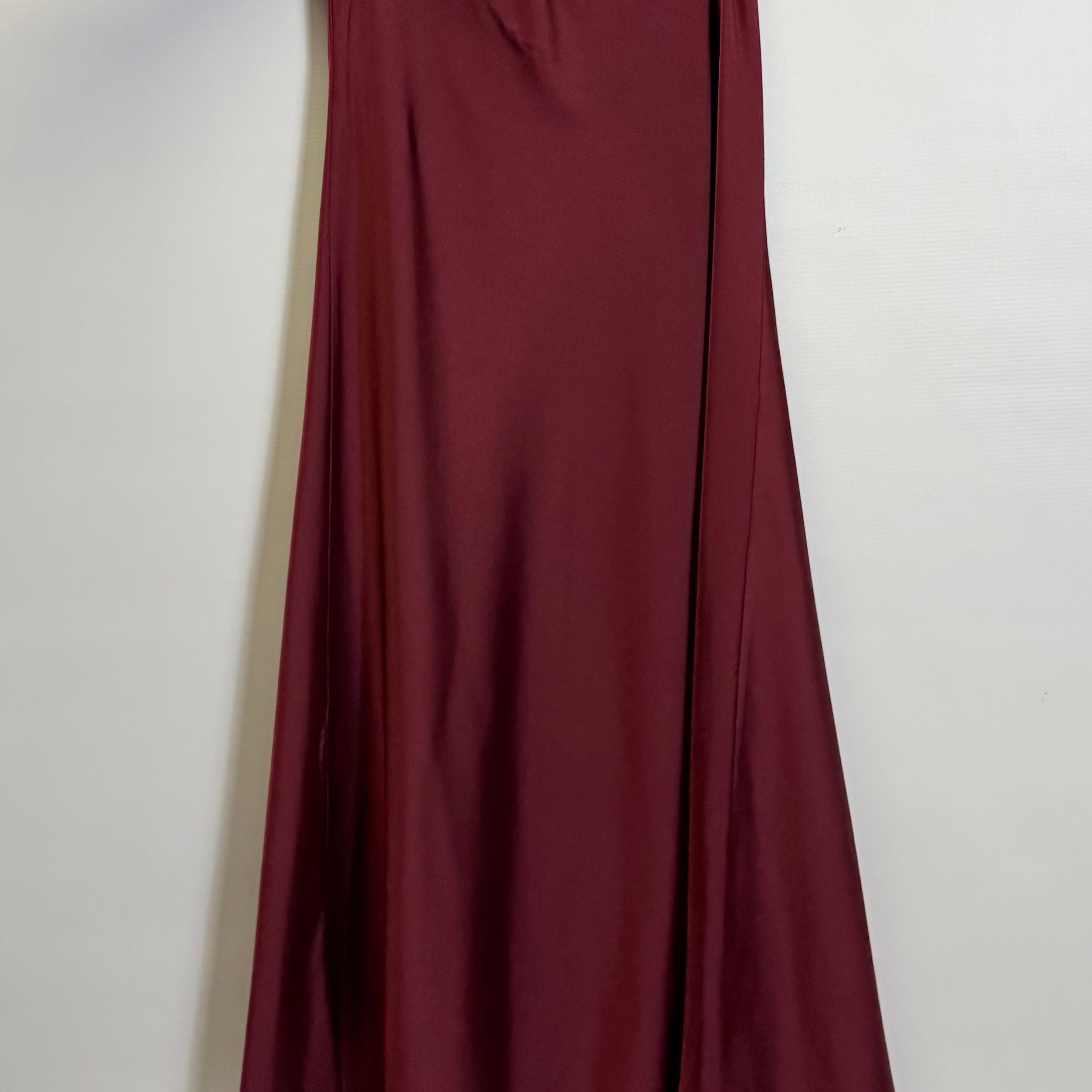 Maroon skirt on a hanger against a white background