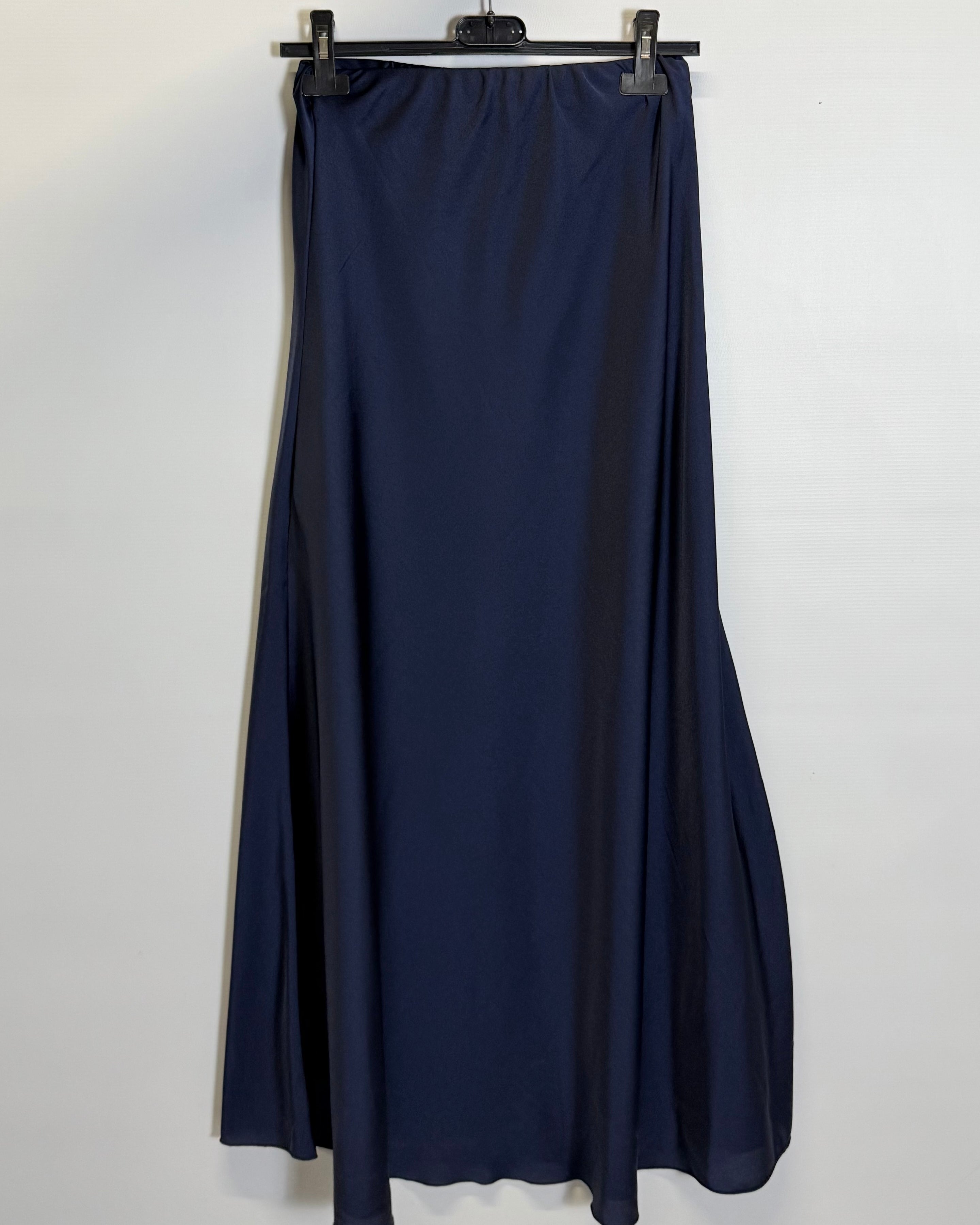 Navy blue skirt hanging on a hanger against a white background