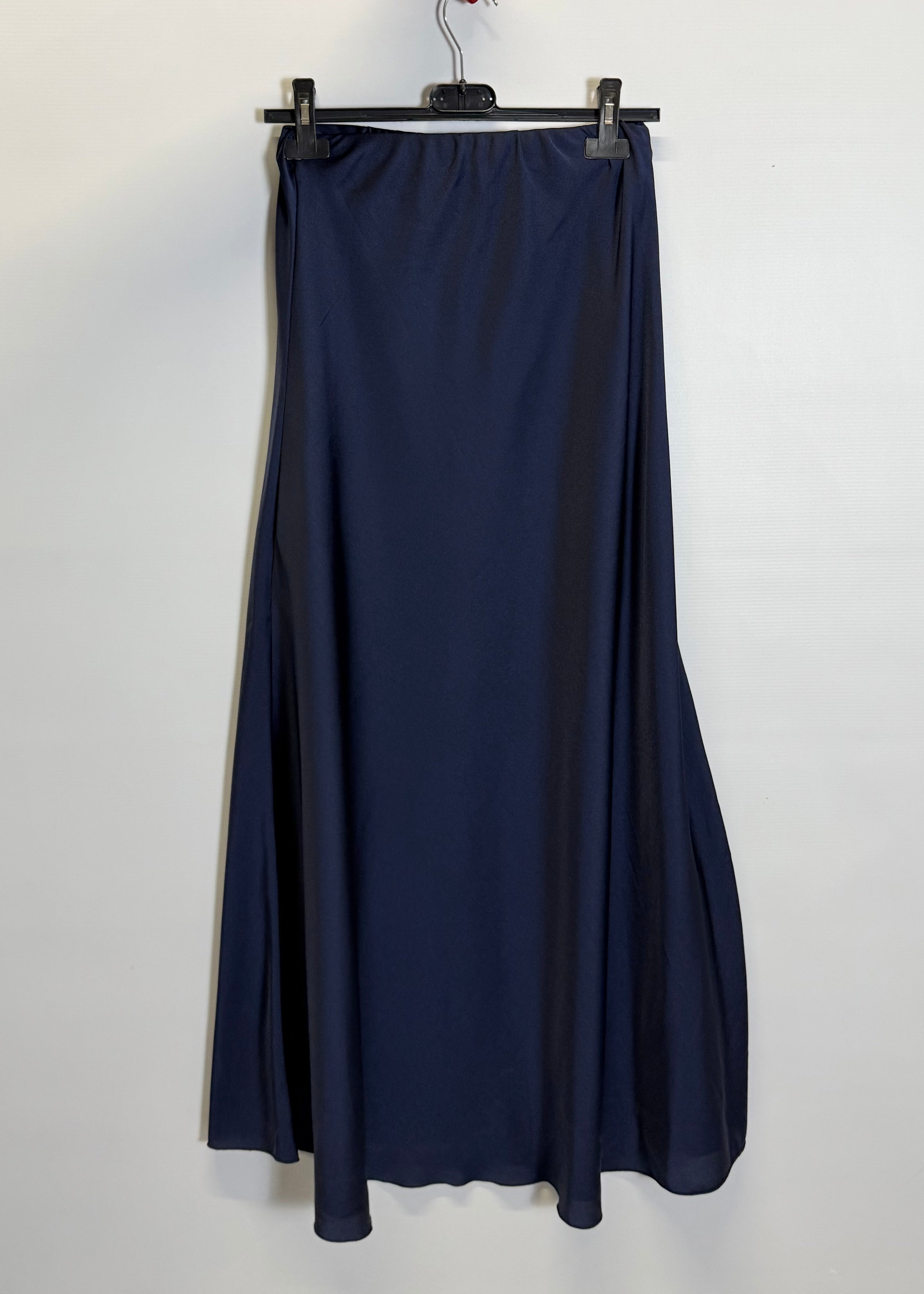 Navy blue skirt hanging on a hanger against a white background