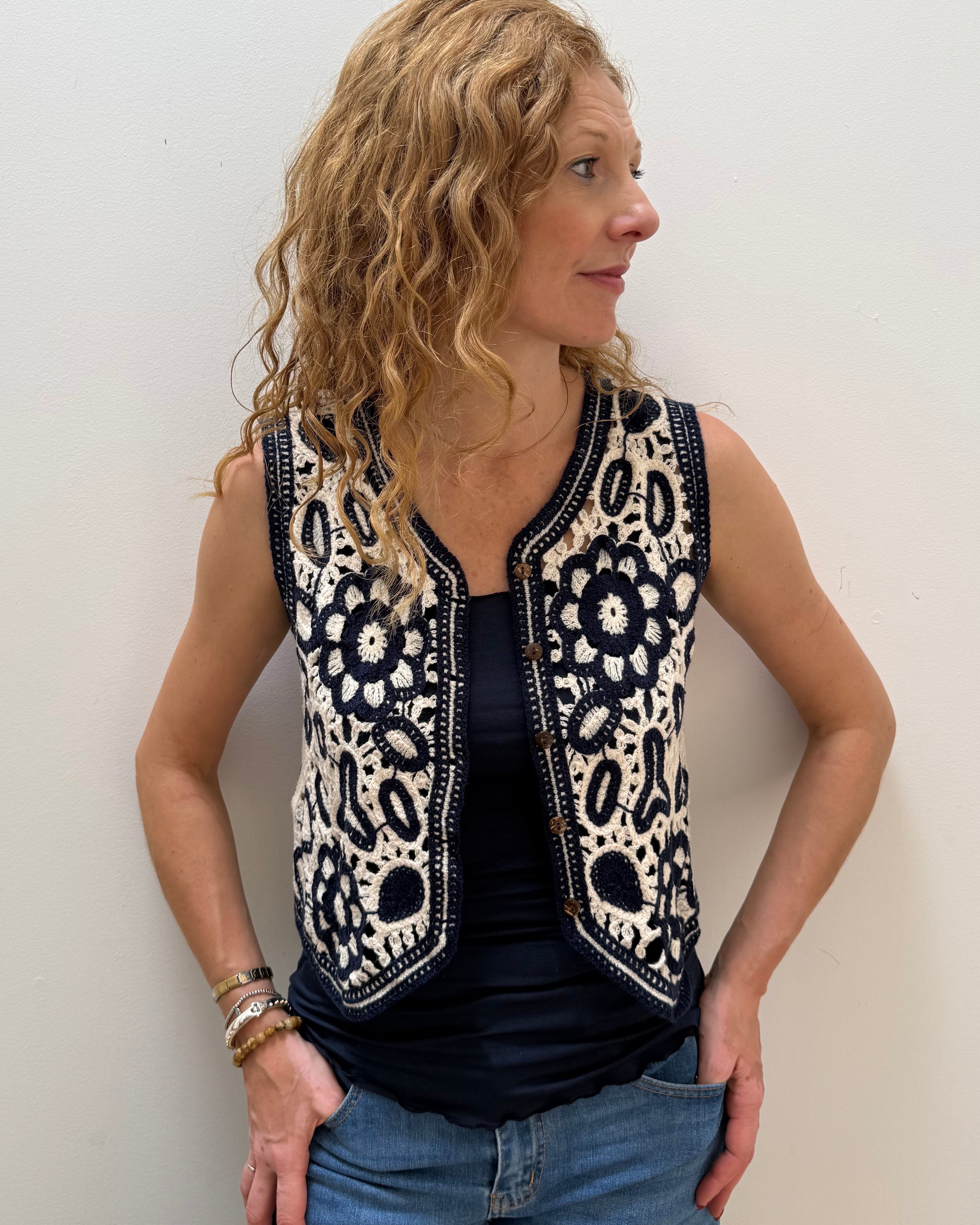 Woman wearing a sleeveless patterned top against a plain background