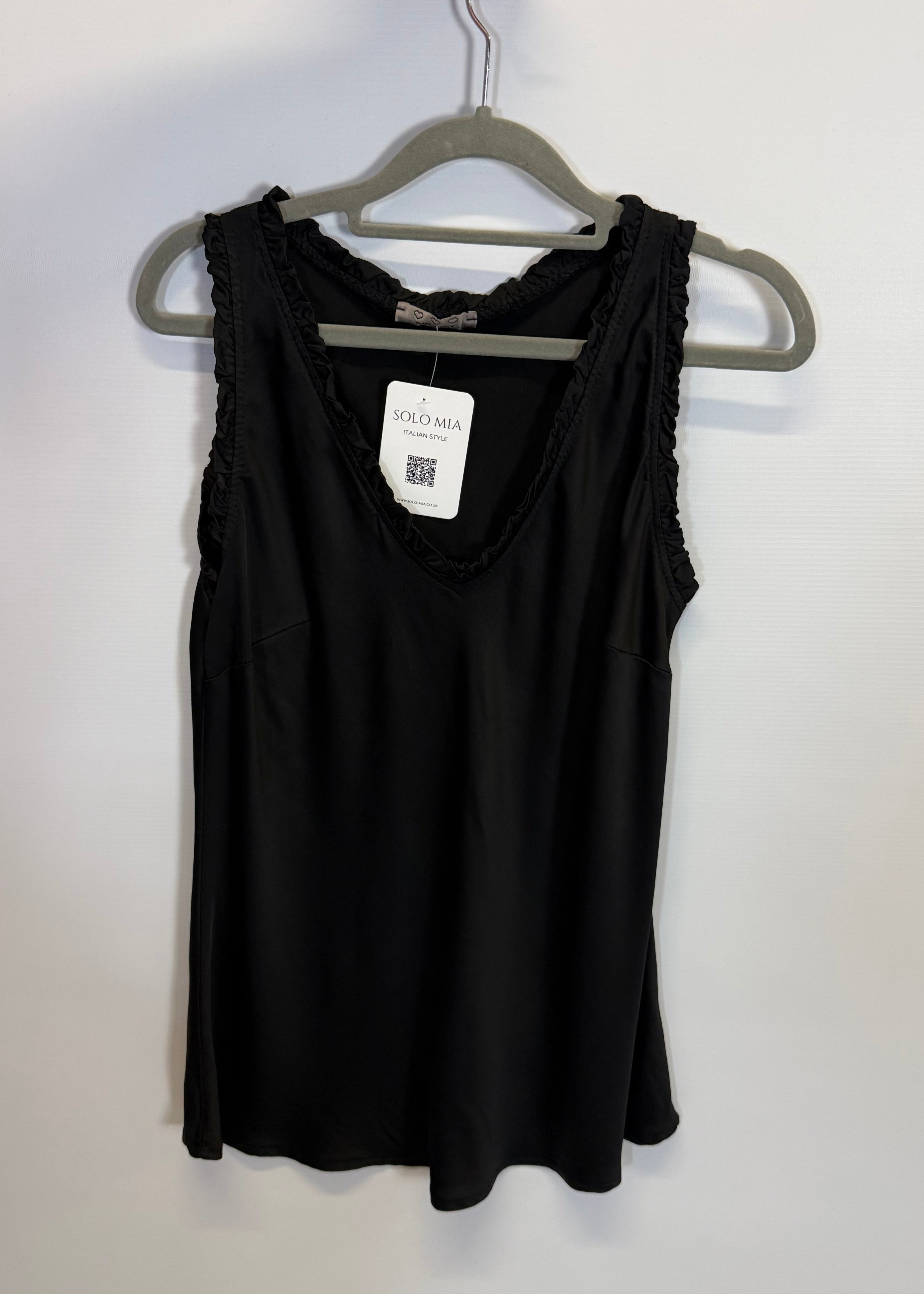 Folded black garment on a hanger with a visible tag against a white background