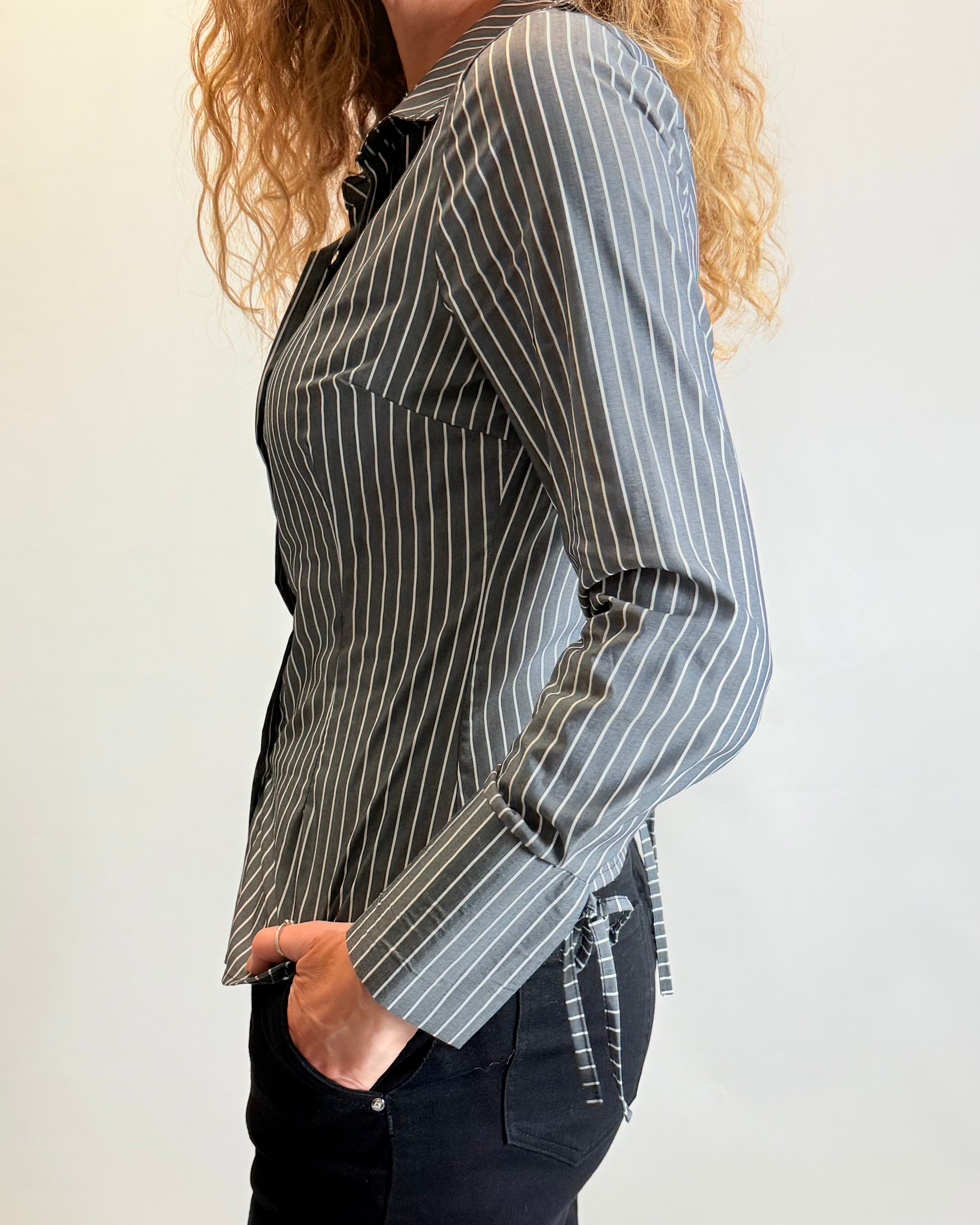 Person wearing a black and white striped shirt with a plain background