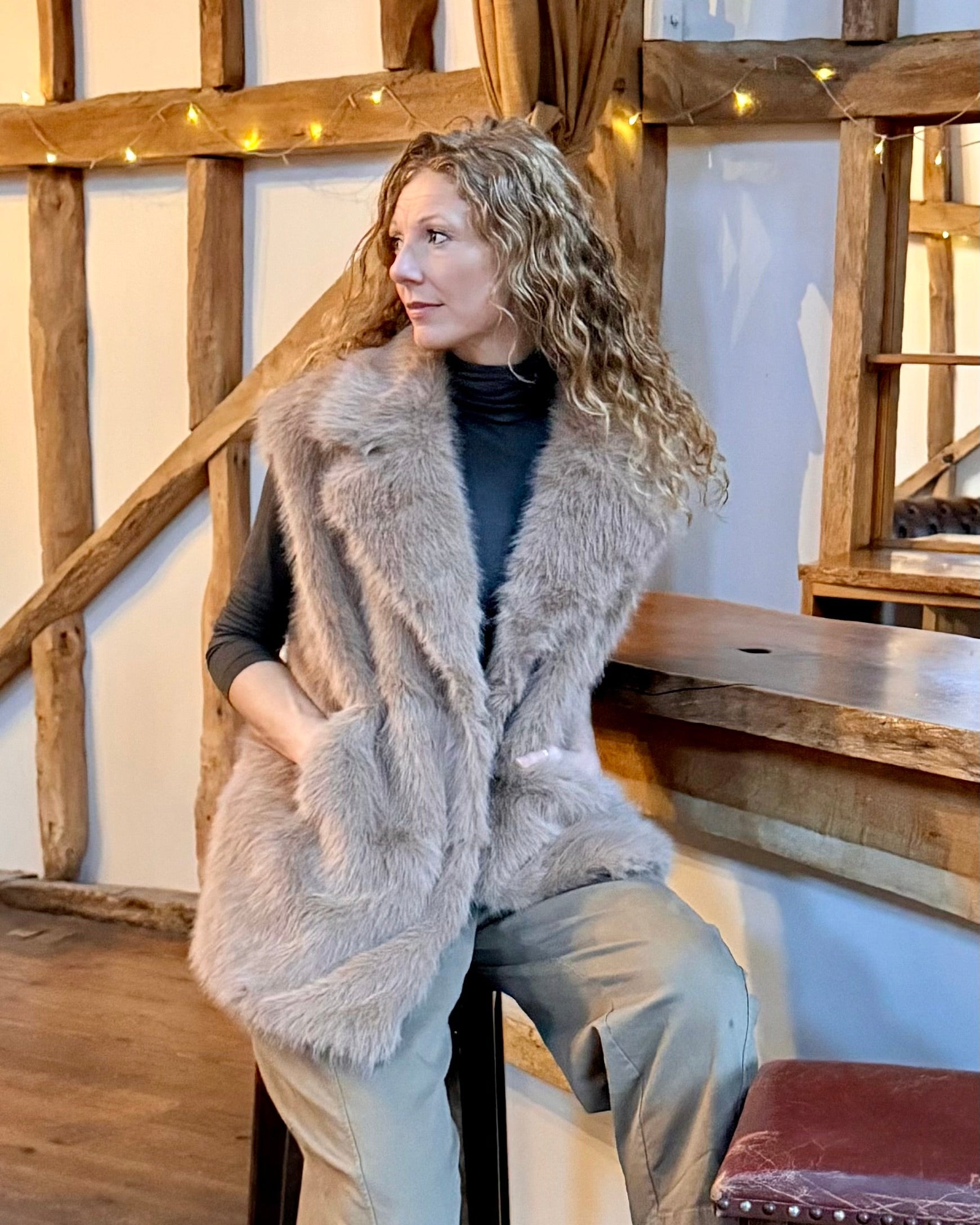 Lady wearing faux fur gilet with black top.