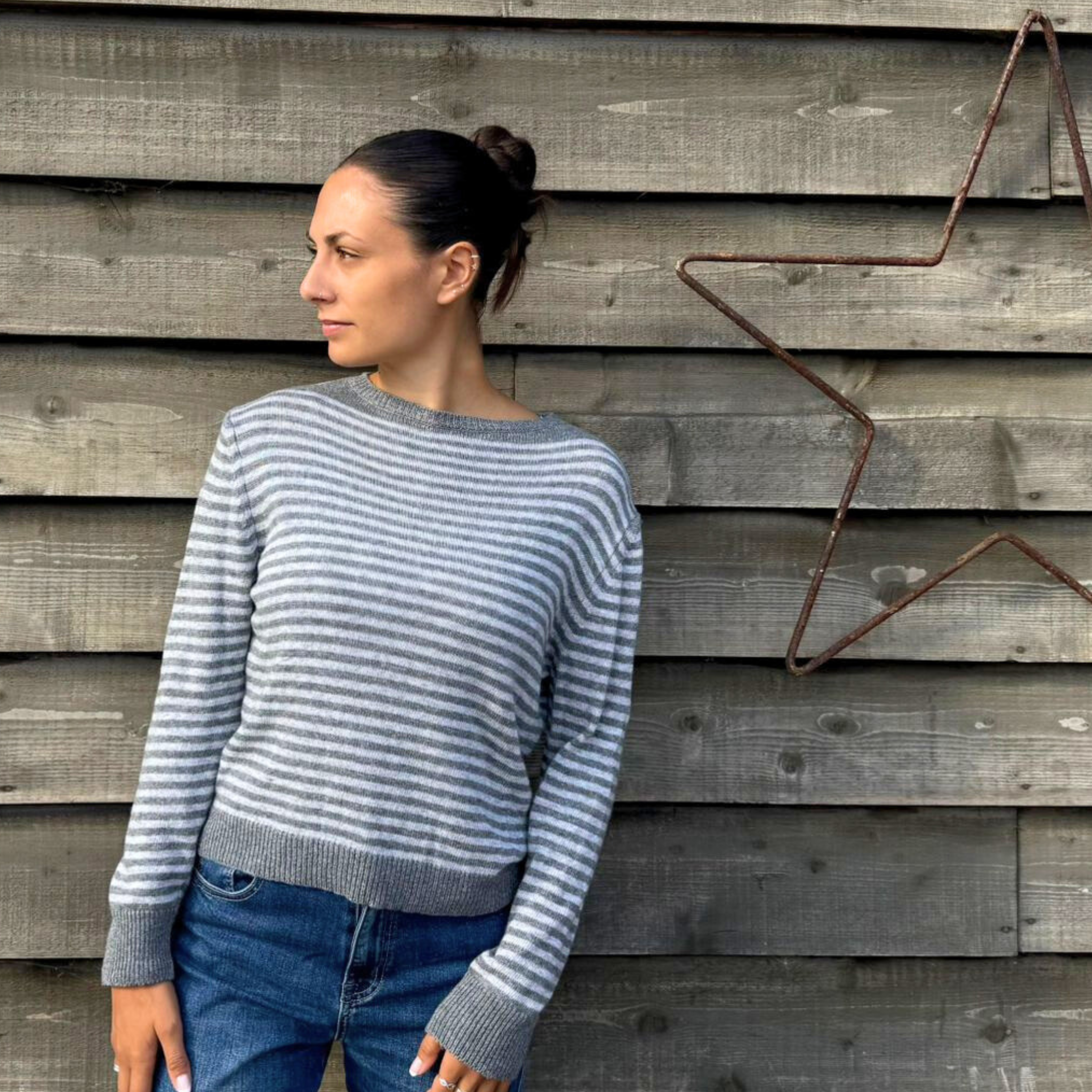 Lady wearing soft knit grey and white stripe jumper.