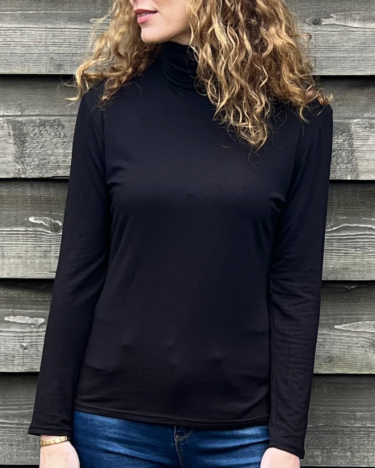 Woman wearing a black strati turtle neck top