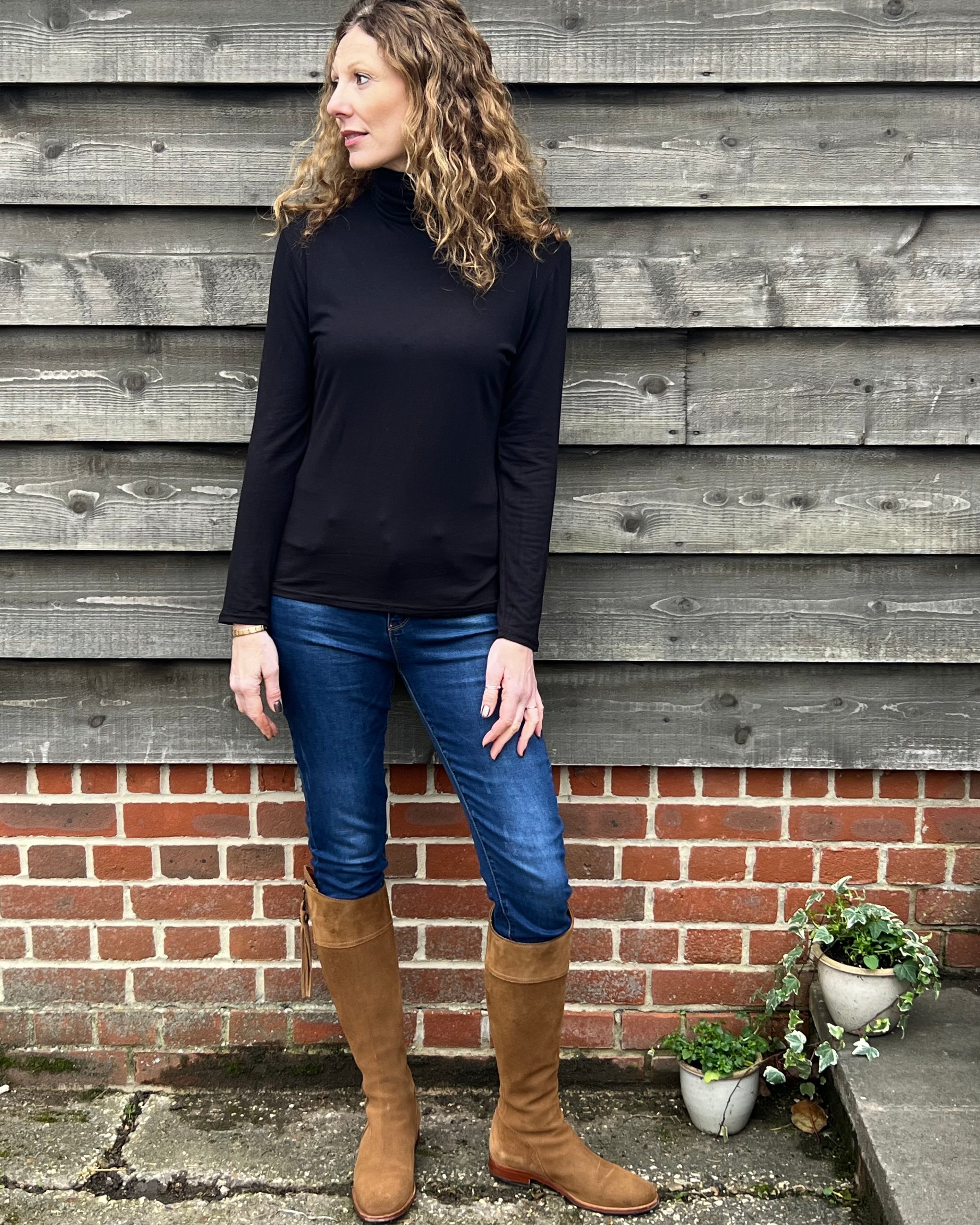 Woman wearing a black strati turtle neck top