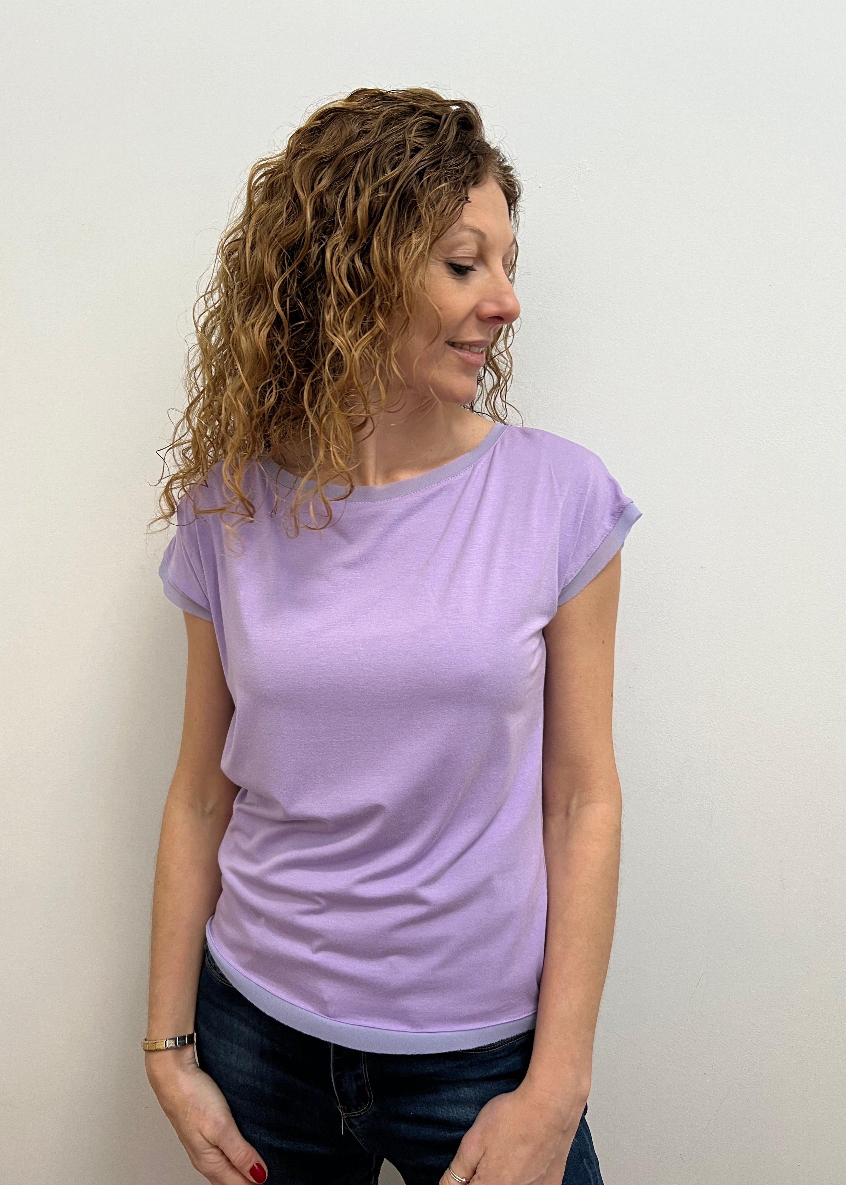 Woman wearing a purple t-shirt against a plain background