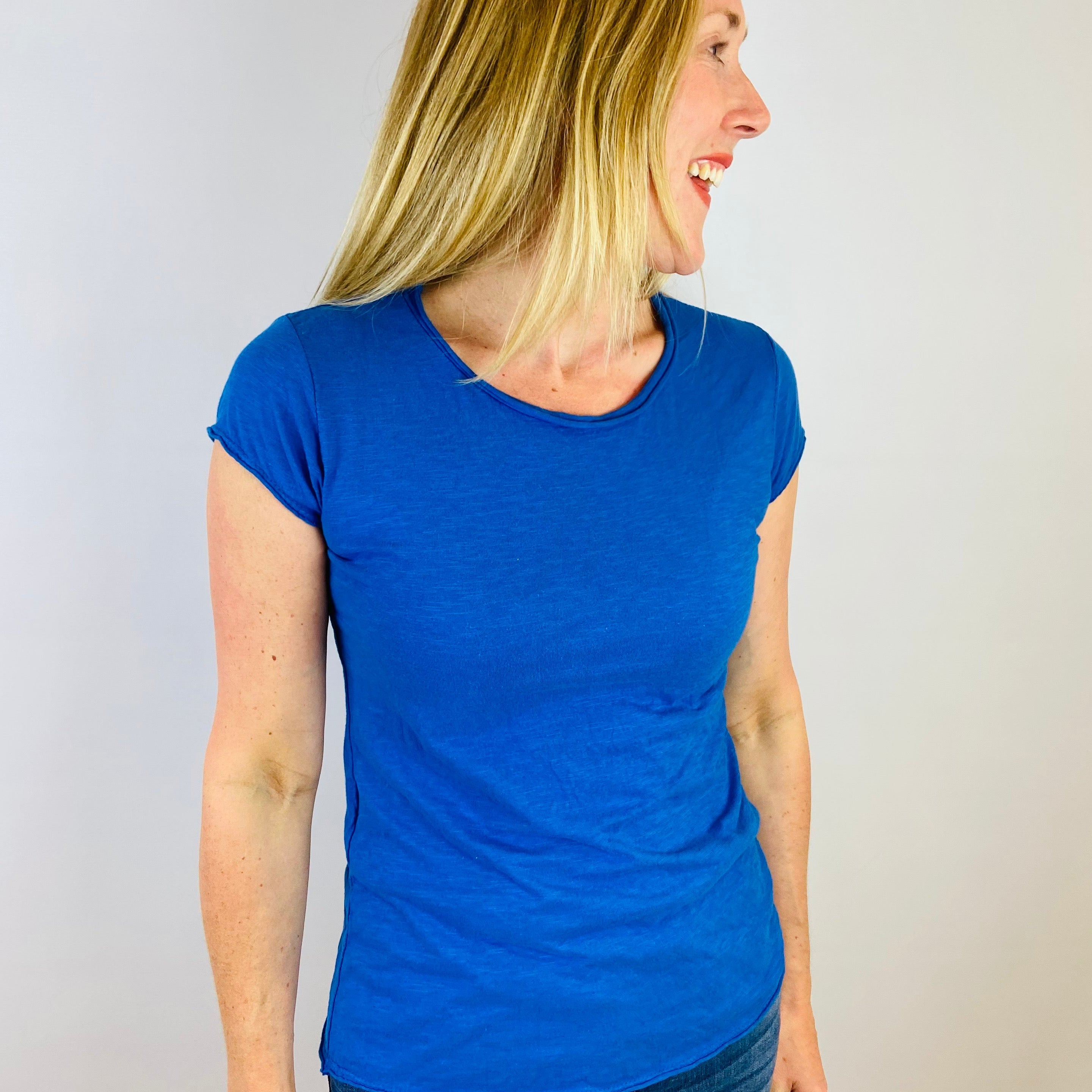 Woman wearing a blue t-shirt against a plain background