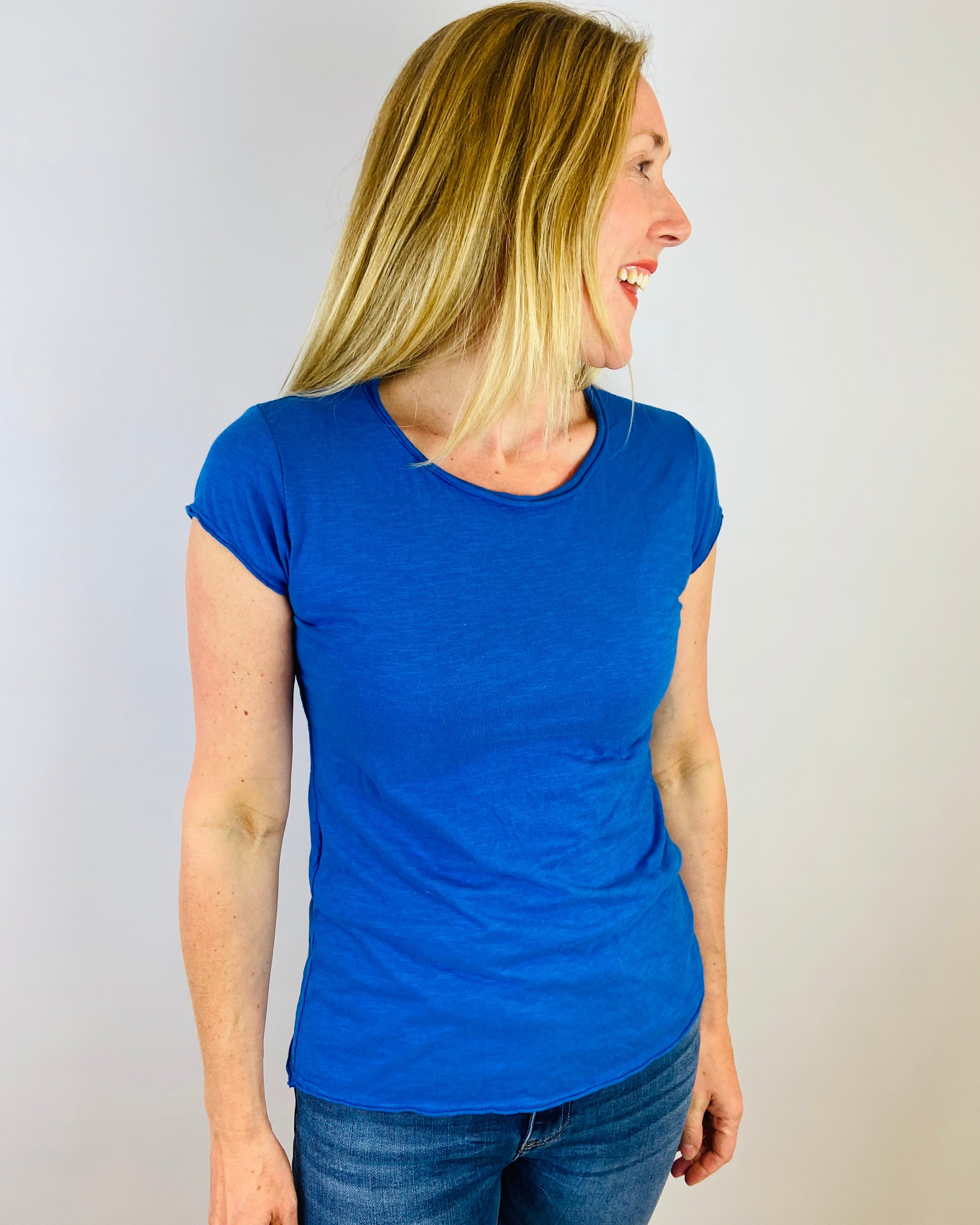 Woman wearing a blue t-shirt against a plain background