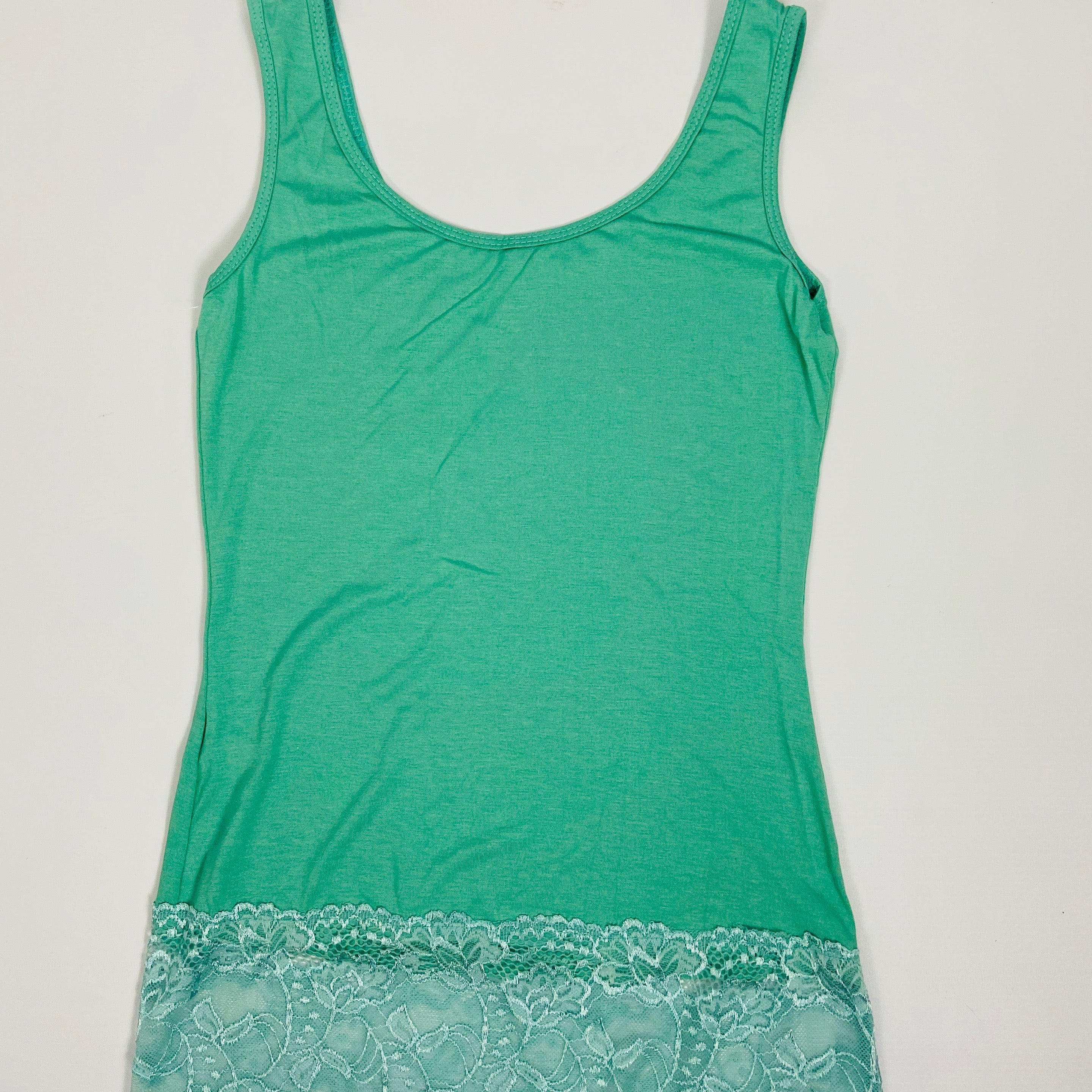 Green tank top with lace trim on a light gray background