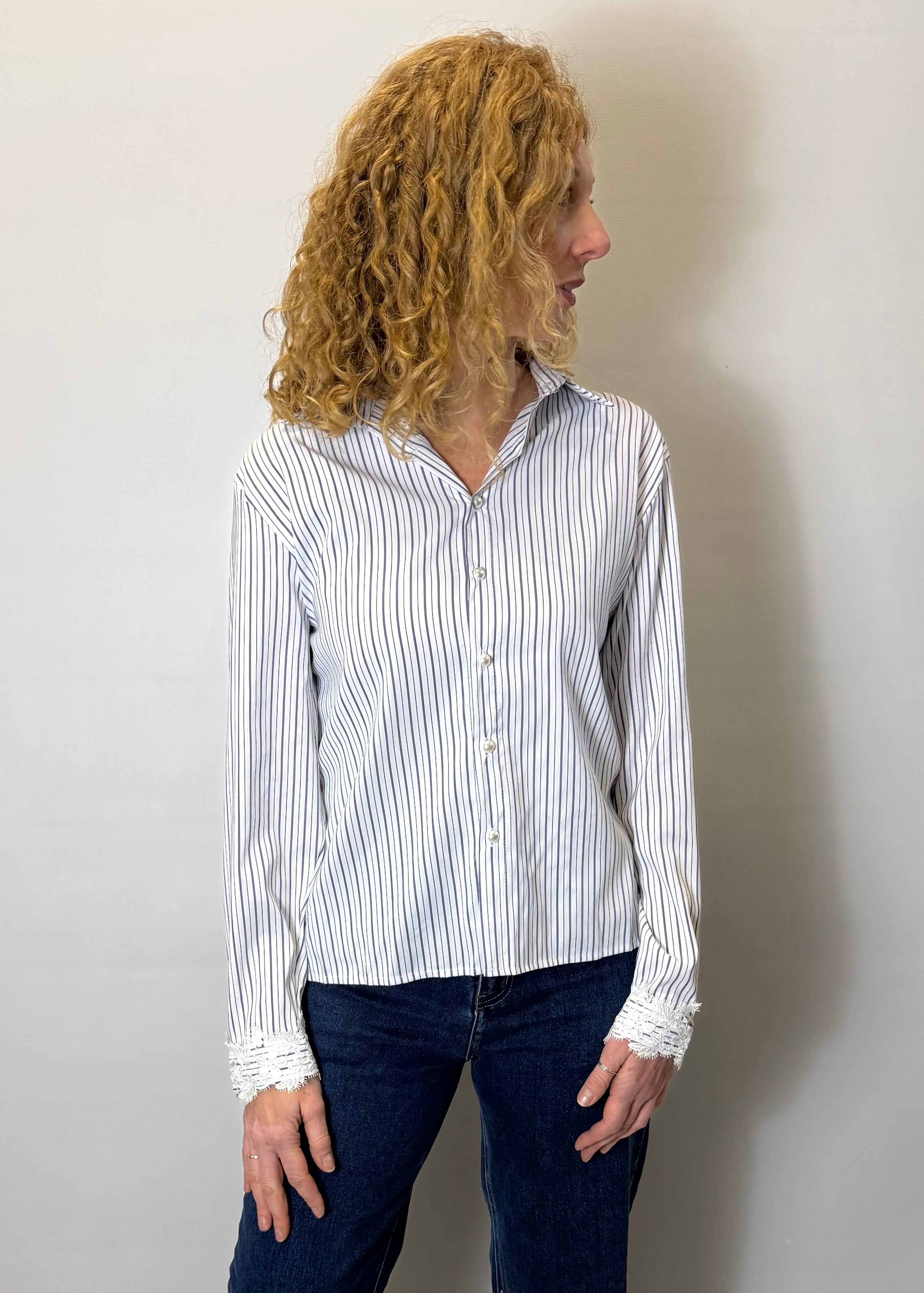 Person wearing a white and black striped shirt against a plain background