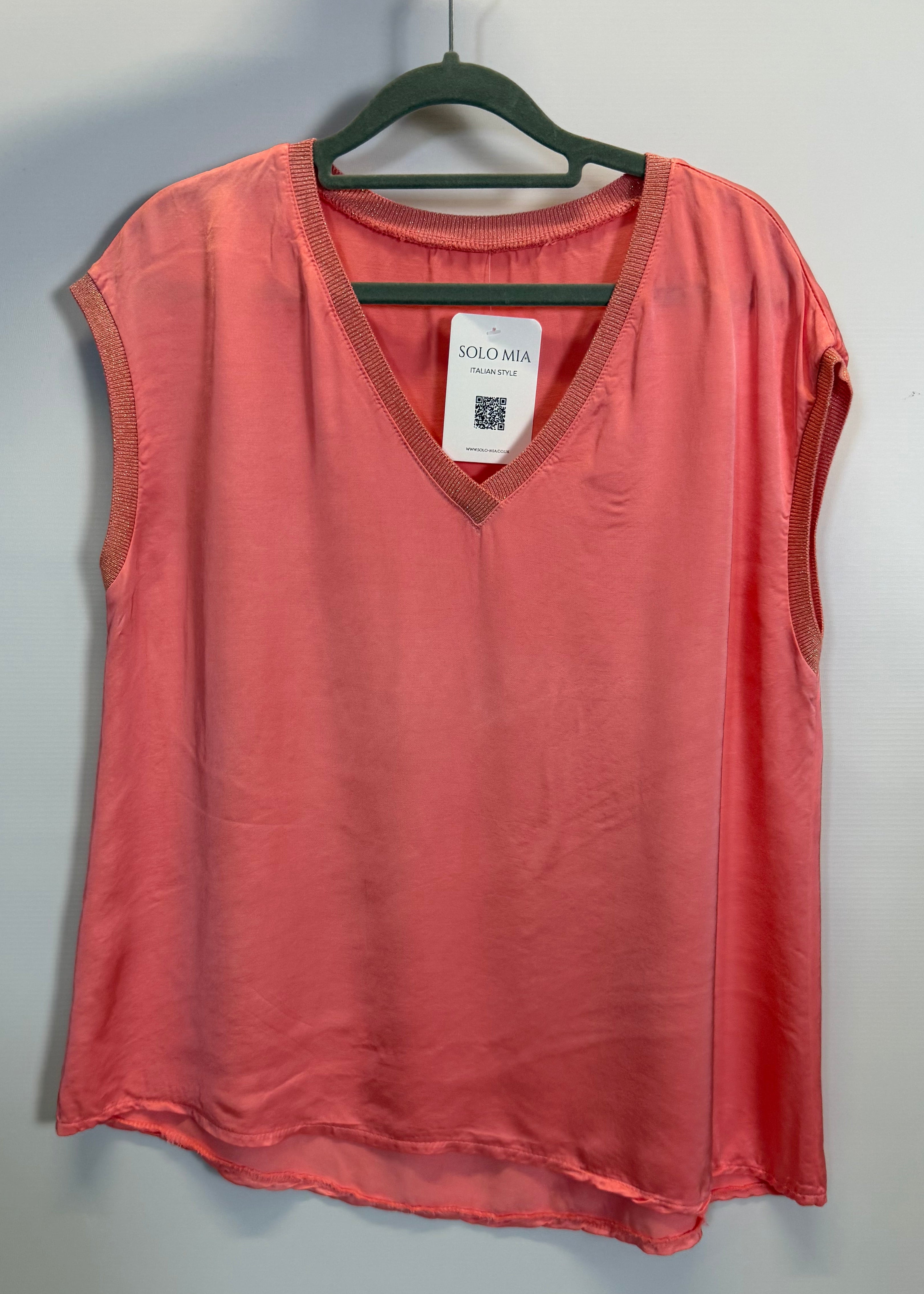 Red shirt on a hanger with a tag against a gray background
