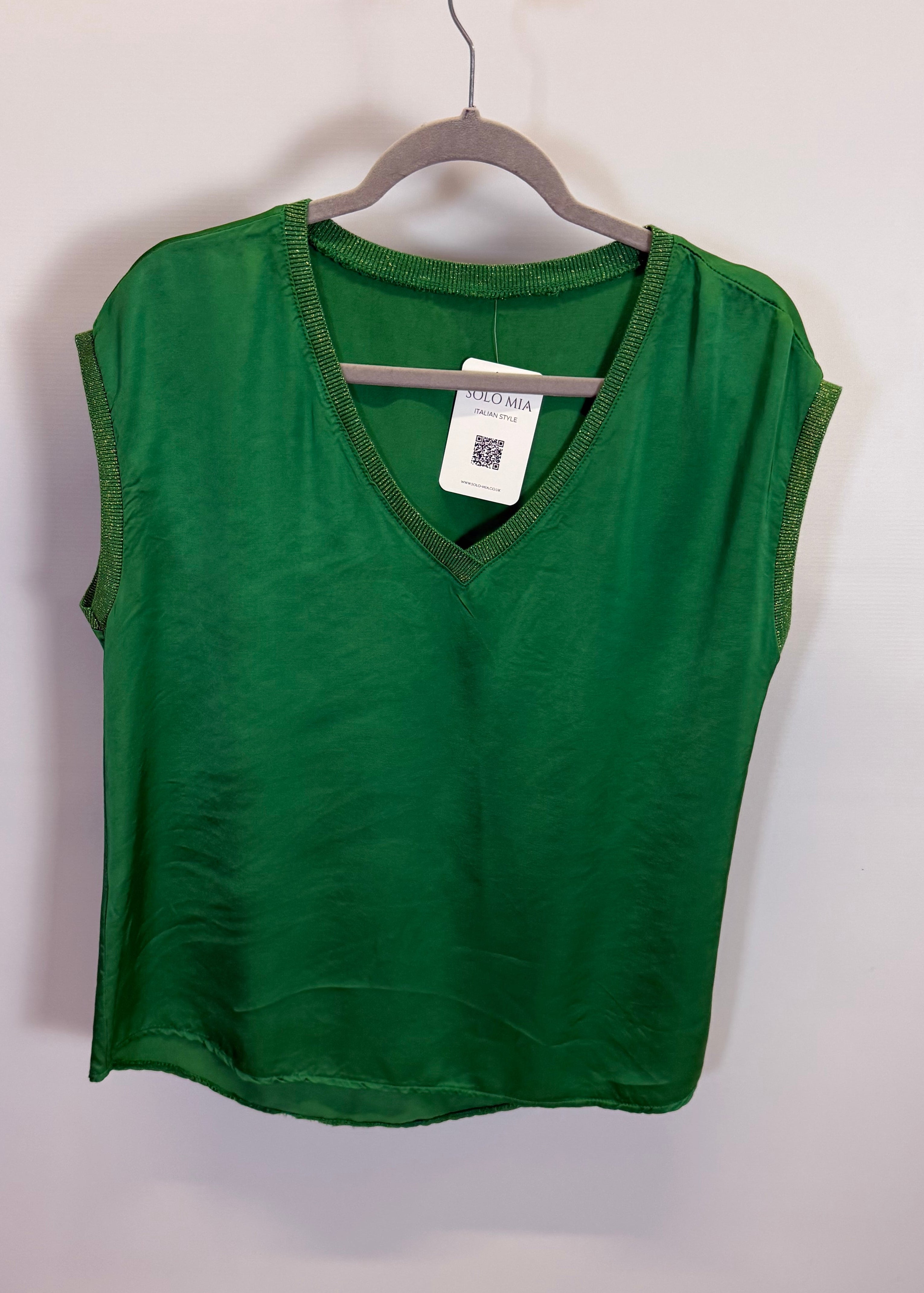 Green t-shirt on a hanger against a plain background