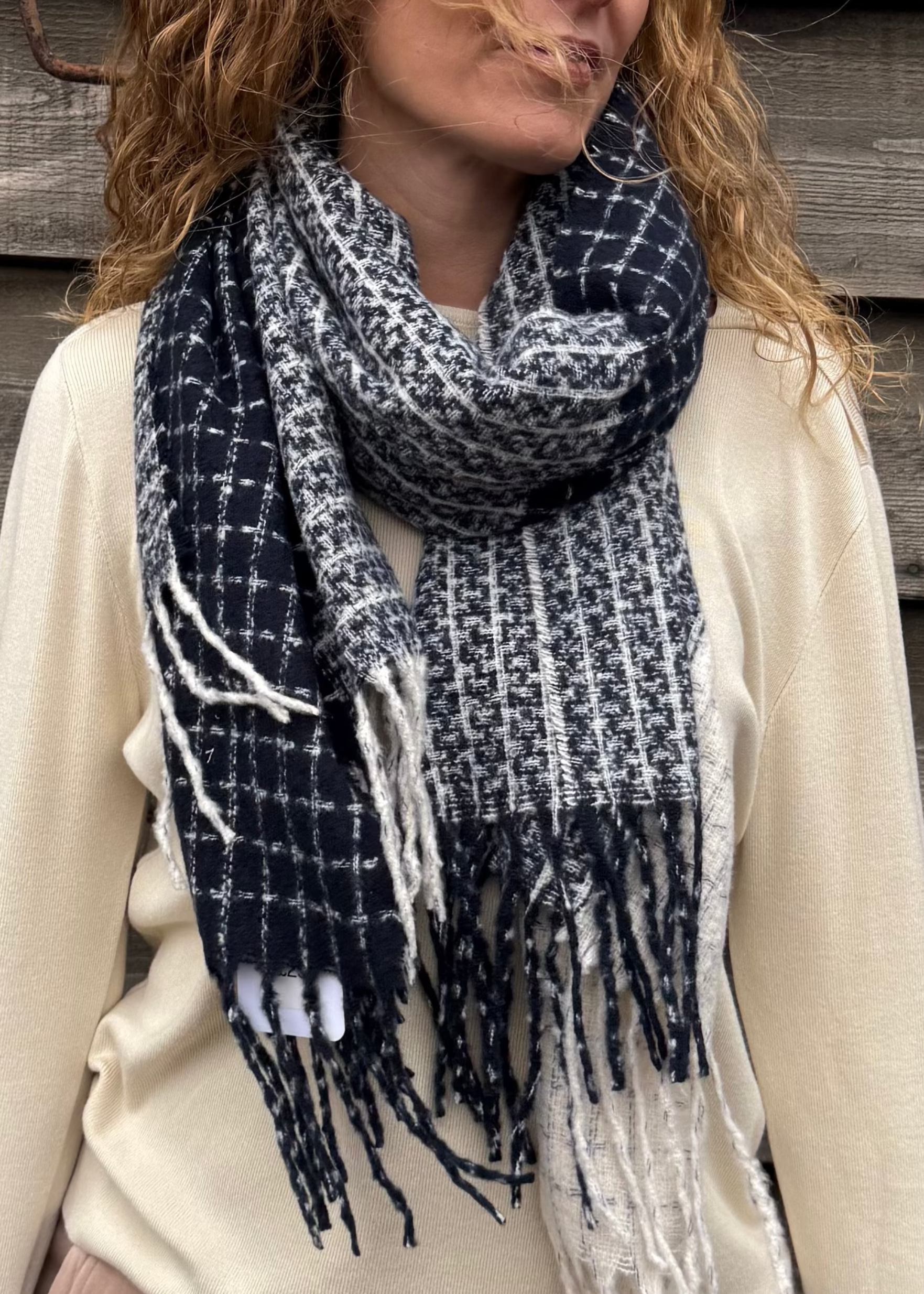 Woman wearing a blue and white plaid scarf against a wooden background