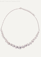 Silver necklace with clear crystals on a white background