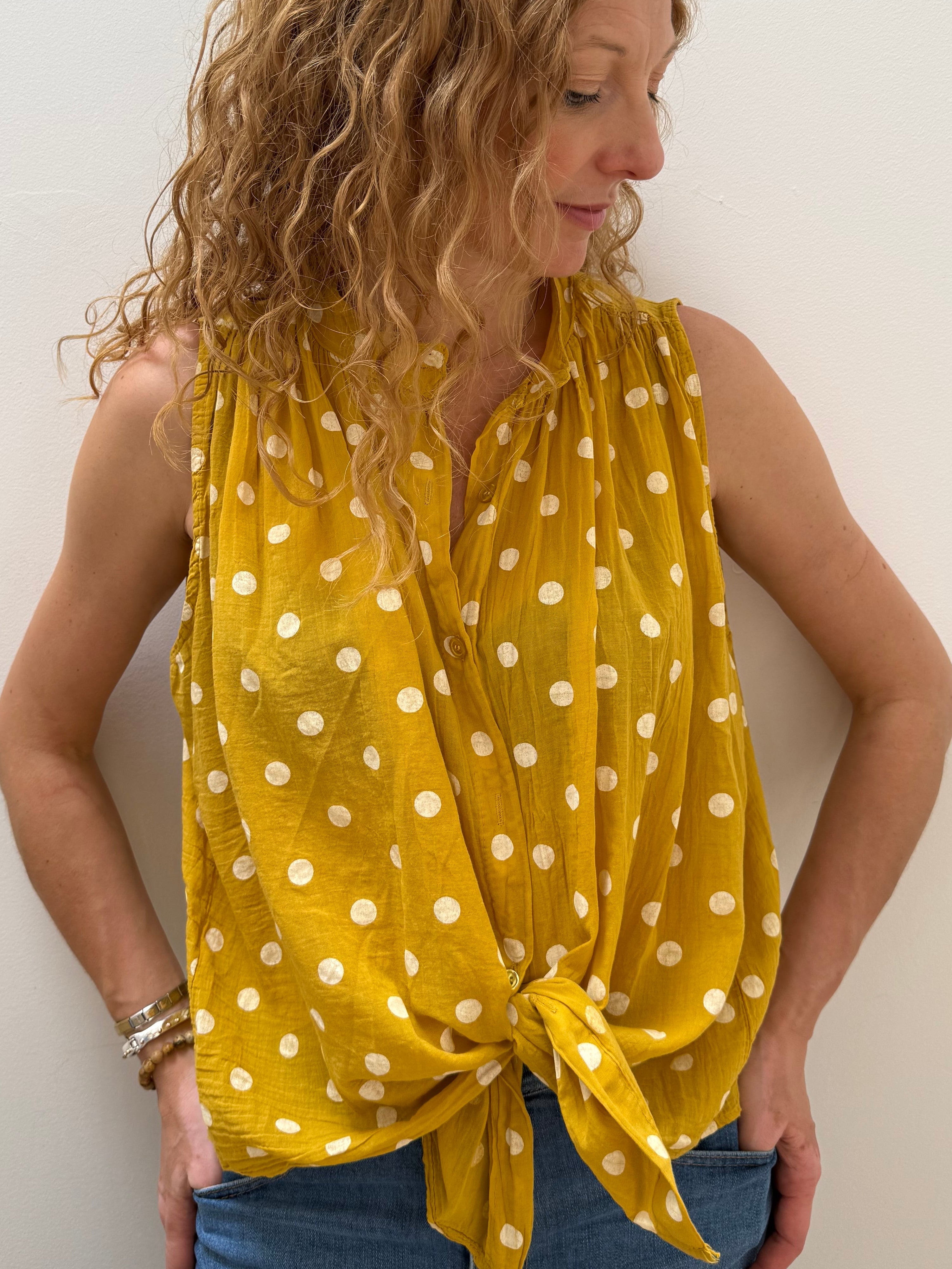 Woman wearing a yellow polka dot dress on a white background