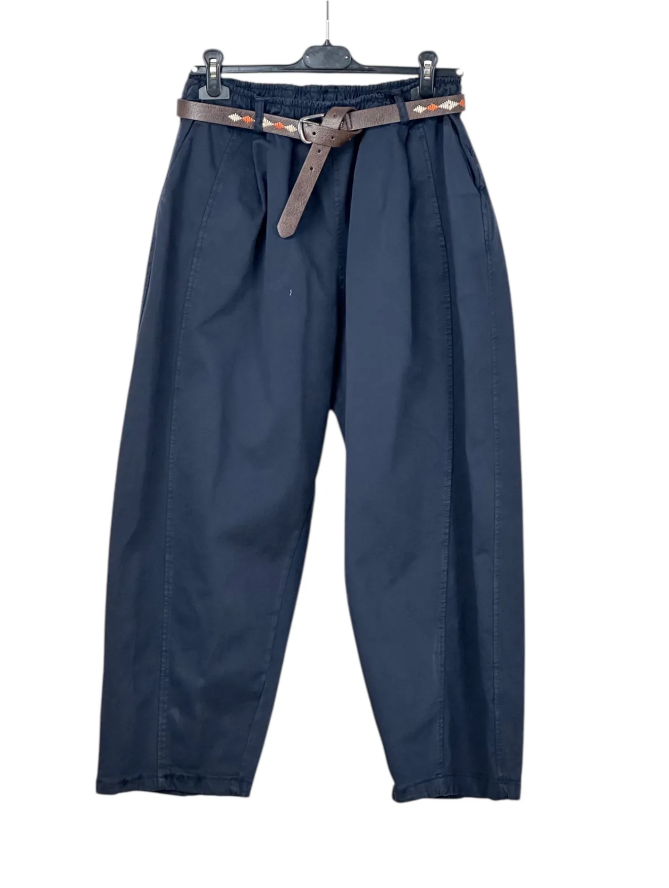 Blue pants with a belt on a hanger against a white background