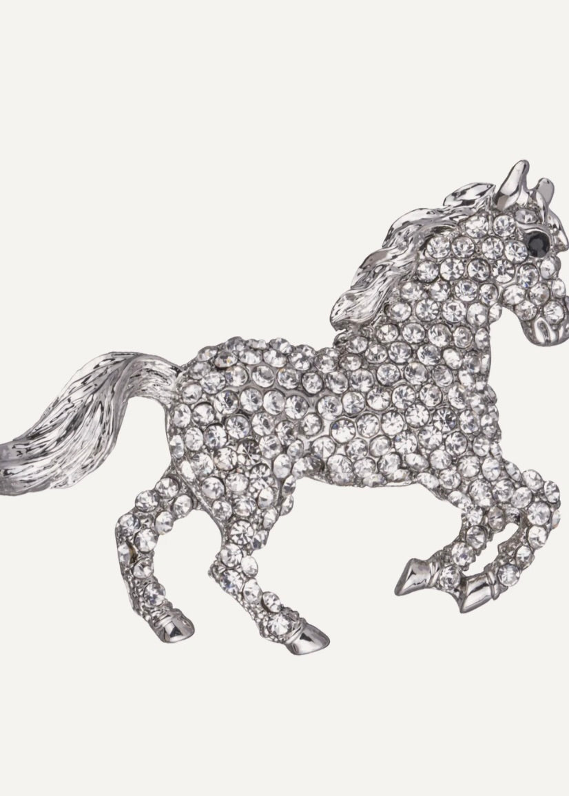 Silver horse-shaped brooch with crystal embellishments on a white background