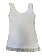 White tank top with lace trim on a brown surface