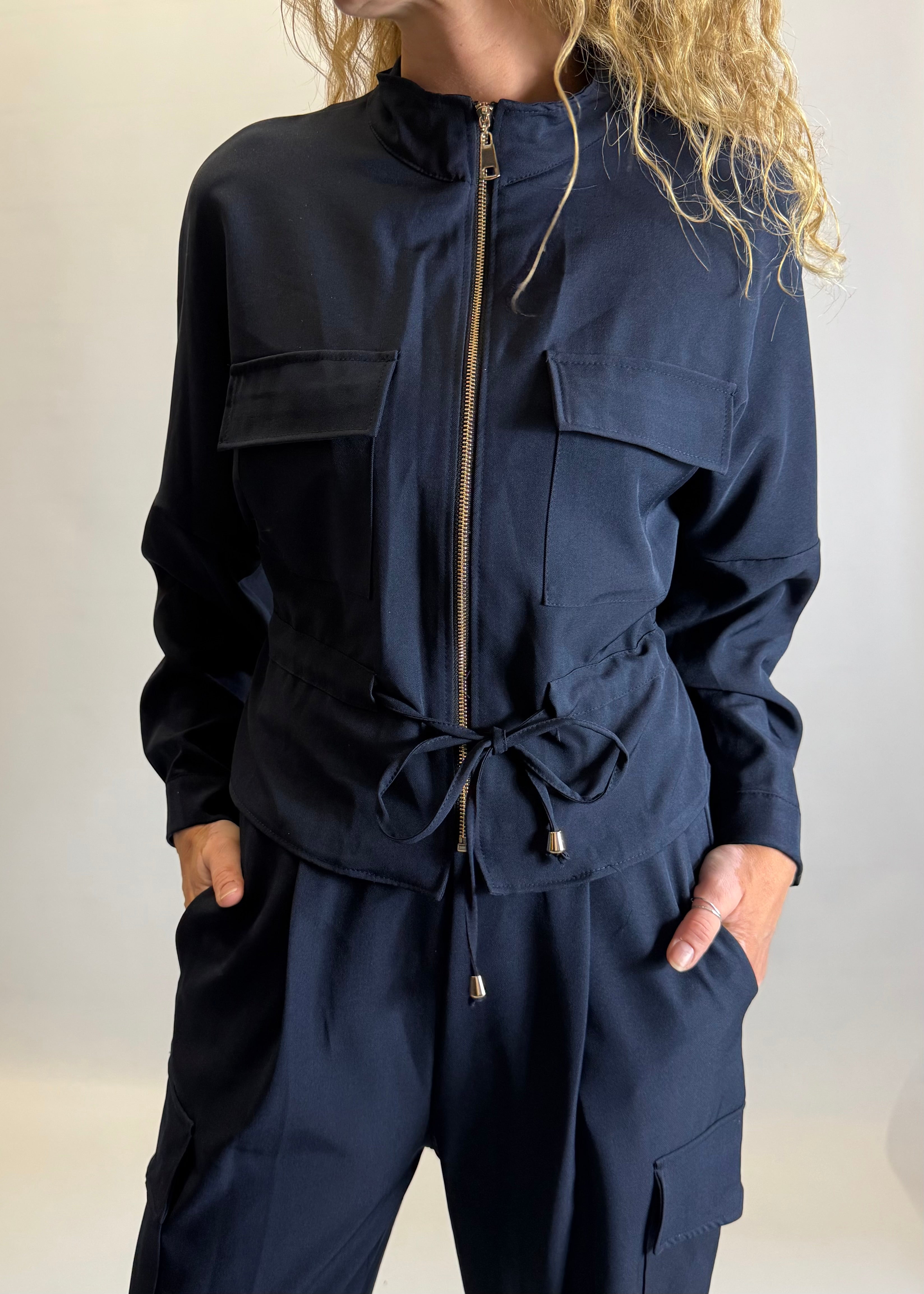 Navy blue jumpsuit with a drawstring waist on a plain background