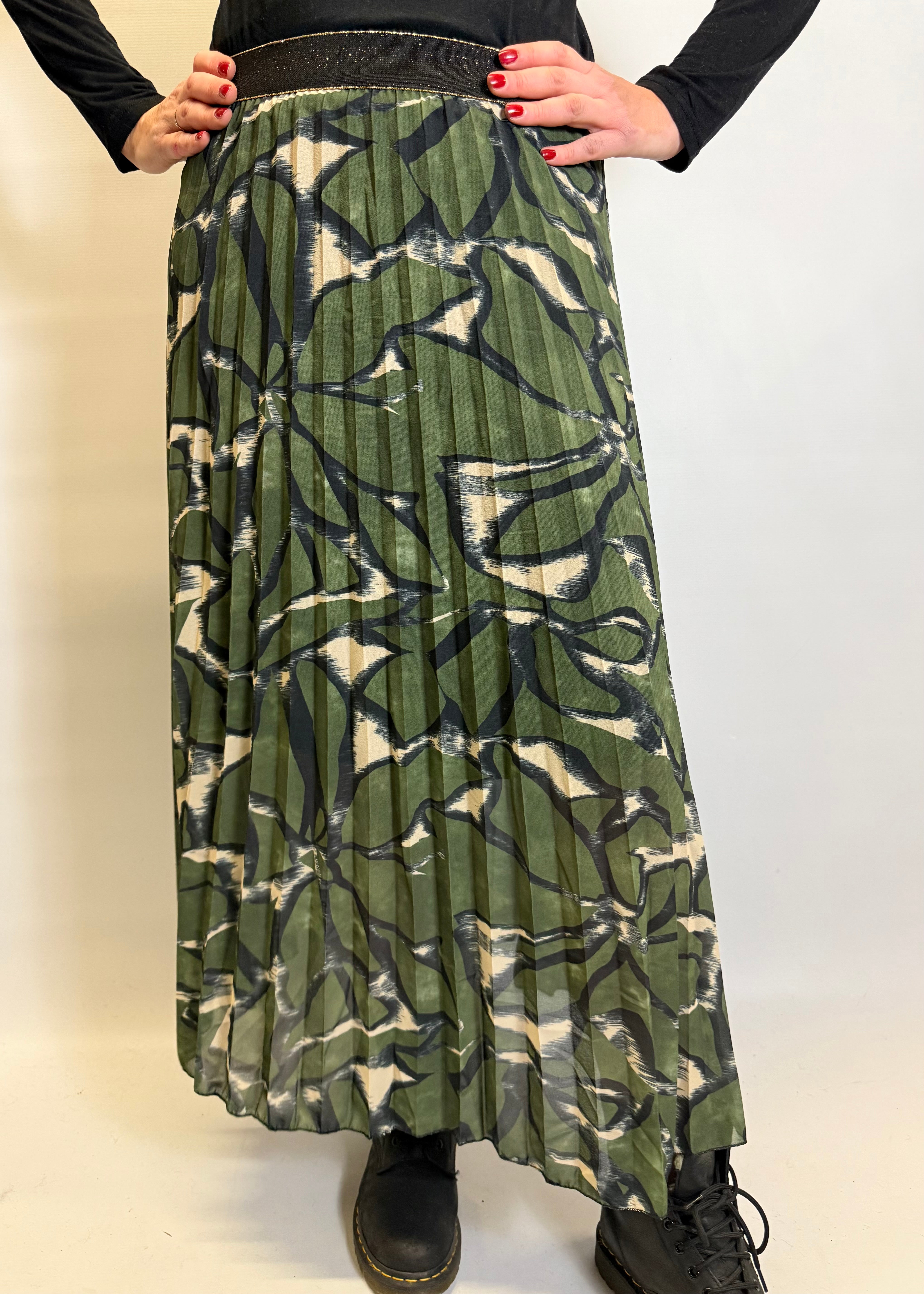 Person wearing a green patterned skirt on a white background