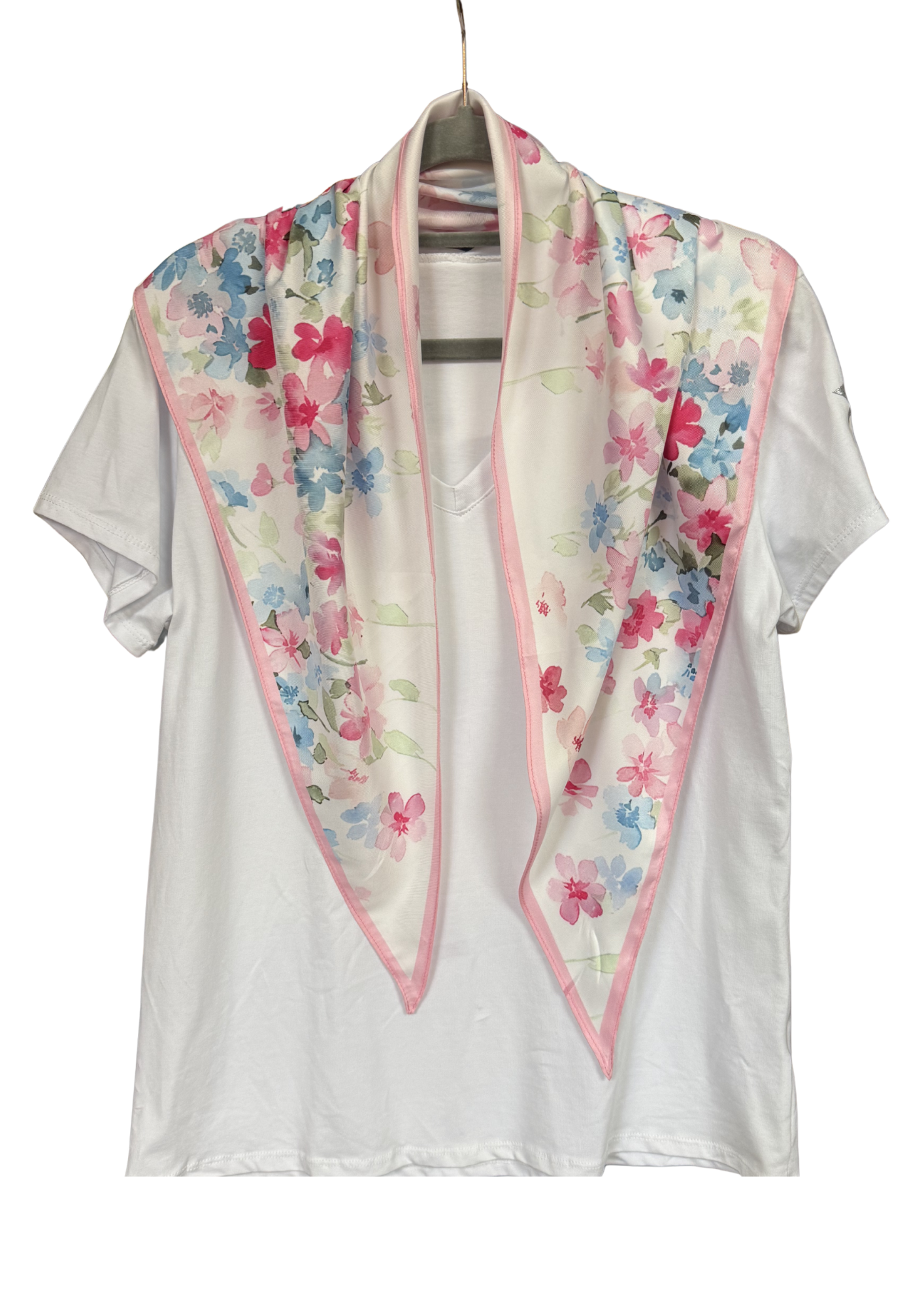 White blouse with a floral scarf draped over it on a hanger