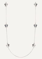 Silver necklace with star-shaped pendants on a white background