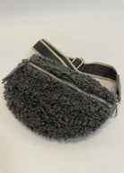 Gray fuzzy fanny pack with a zipper on a white background