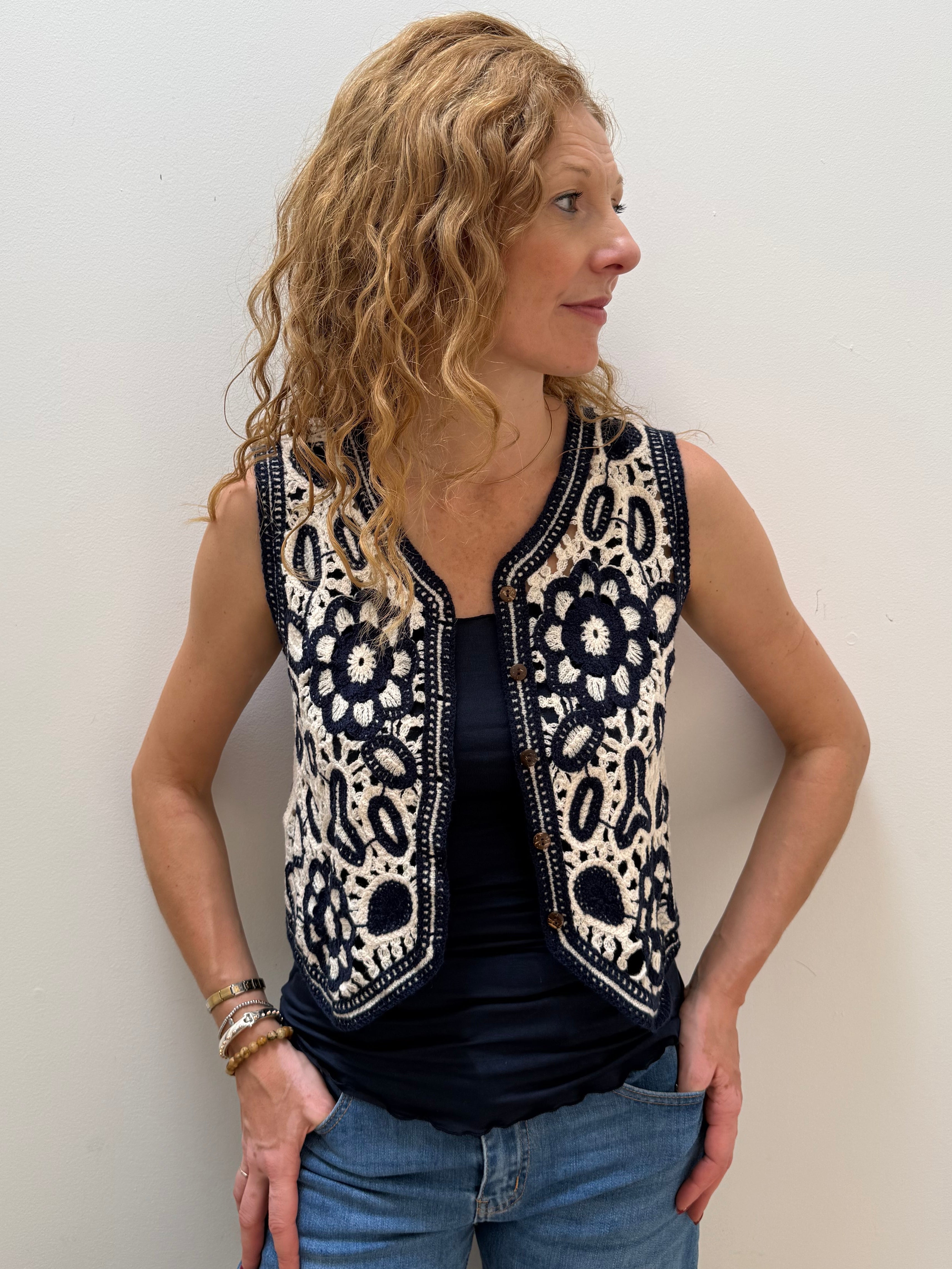 Woman wearing a sleeveless patterned top against a plain background